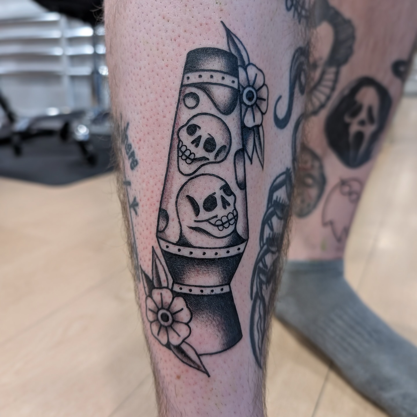 Skulls and dagger black and grey tattoo on the calf by Kaley, Des Moines, Iowa