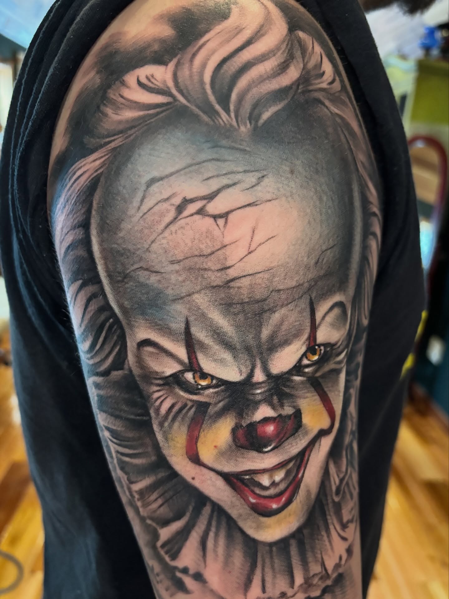 Clown realism tattoo on the upper arm by Komfort Kristy