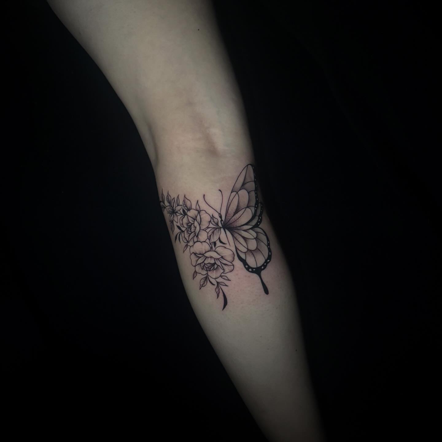 Butterfly and flowers black and grey tattoo on the forearm by Sad Girl Tattoos