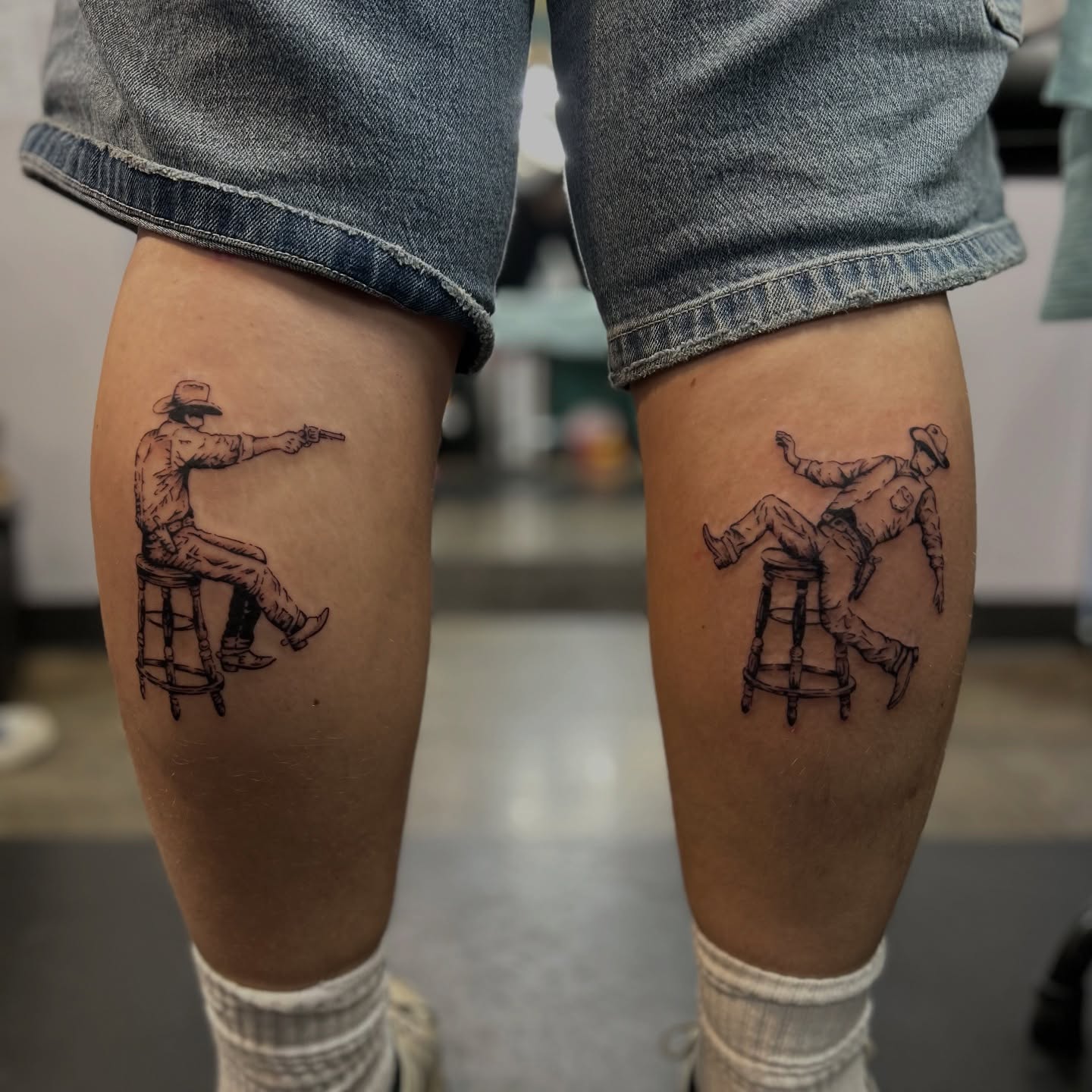 Cowboy sitting on stool black and grey tattoo on the thigh by Natalie Johnson, Minneapolis, Minnesota