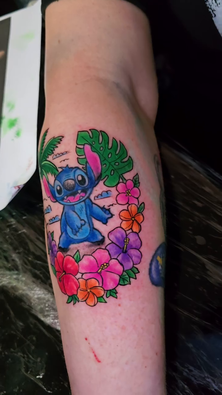 Stitch with tropical flowers new school tattoo by Jesse James, Las Vegas, Nevada