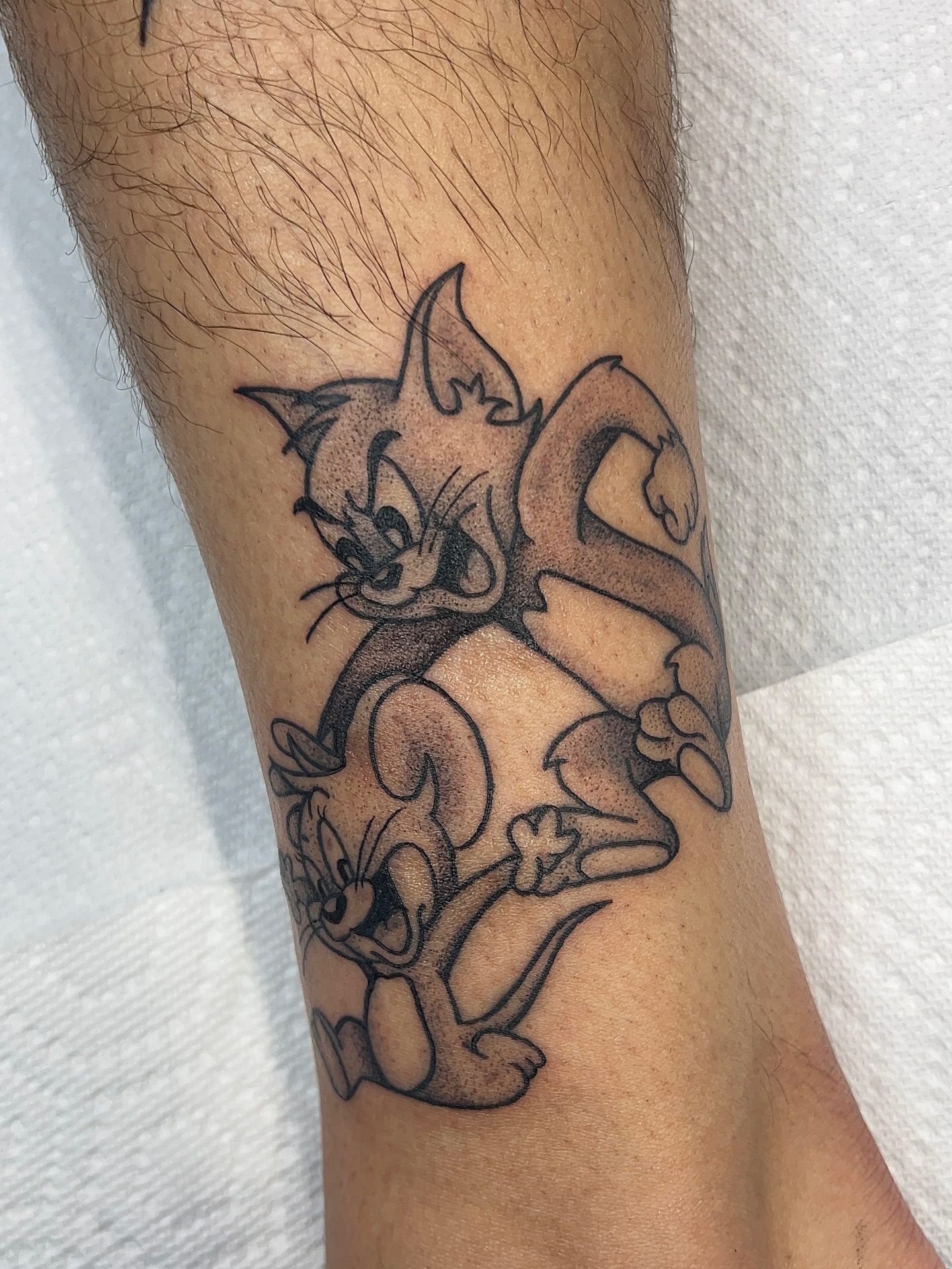 Tom and jerry black and grey tattoo on the forearm by 𝑴𝒂𝒚𝒂𖤐𝑫𝒆𝑽𝒊𝒏𝒆, Dayton, Ohio