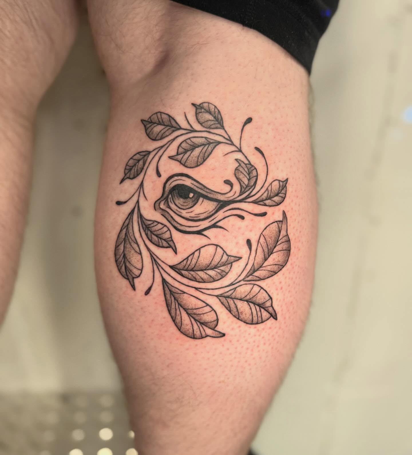 Eye with leaves dotwork tattoo on the thigh by Felicity