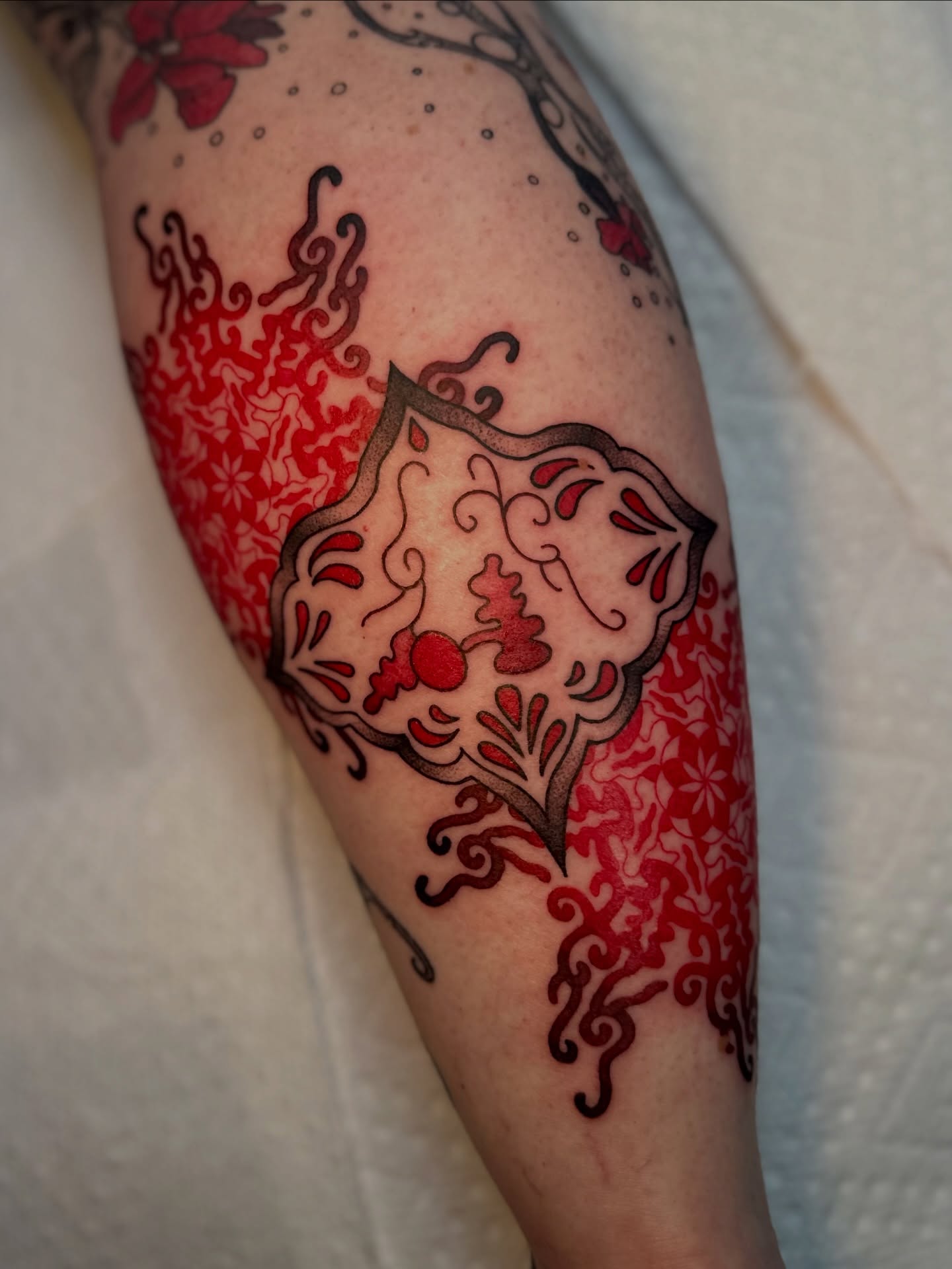 Shield with floral patterns ornamental tattoo on the forearm by Ghost