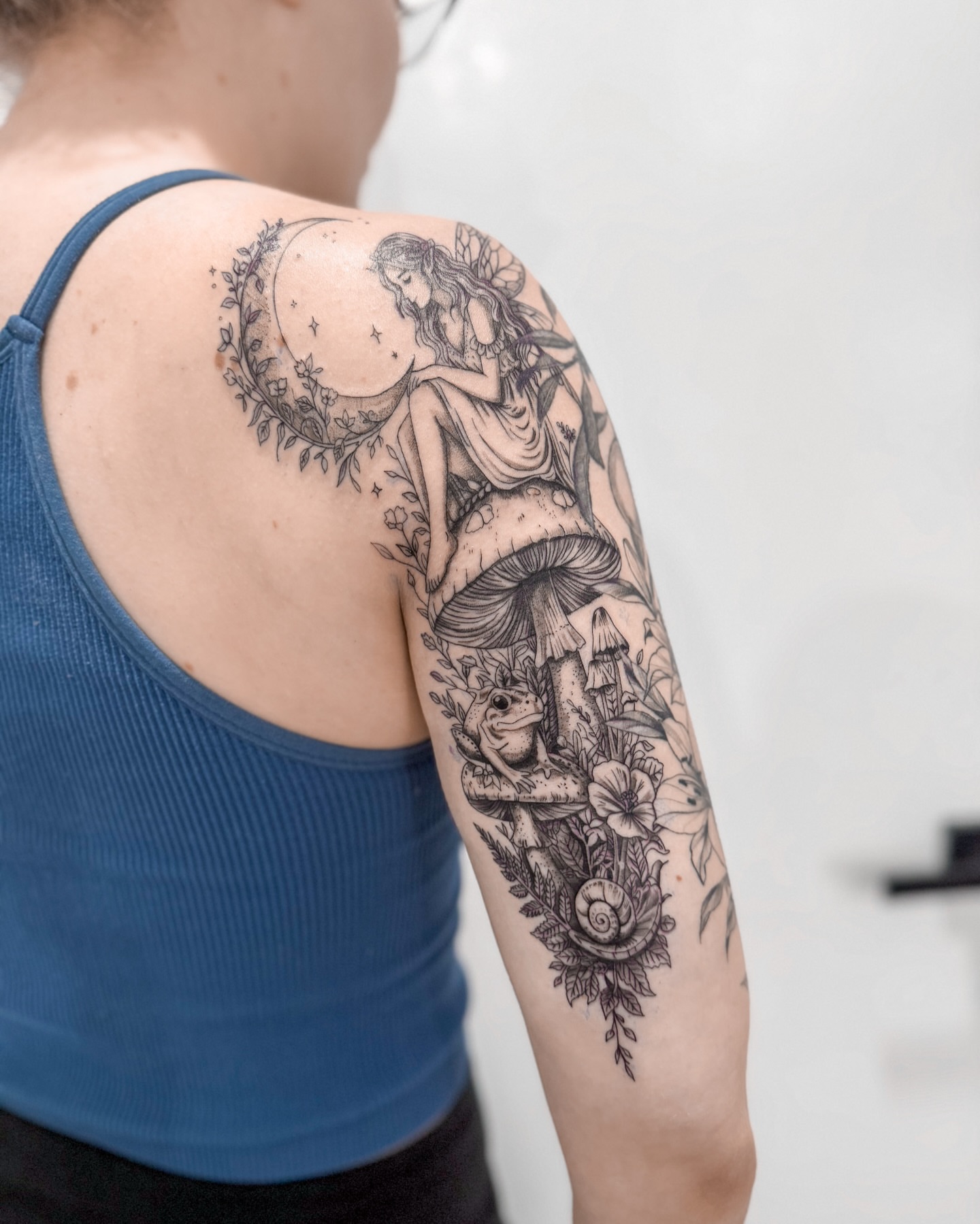 Fairy and crescent moon realism tattoo on the upper arm by The Tattoo Plug