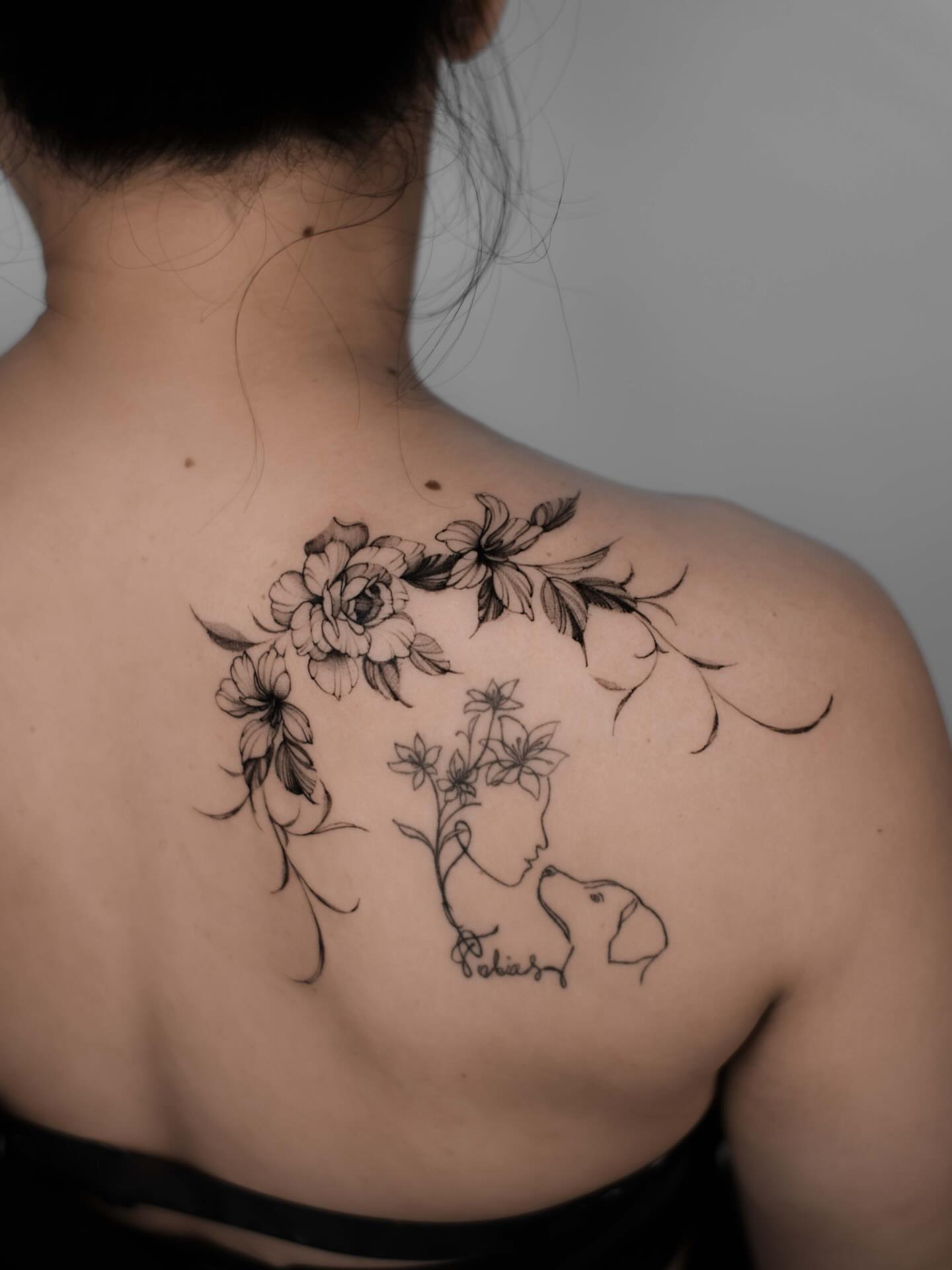 Floral portrait fine line tattoo on the back by Anastasiia