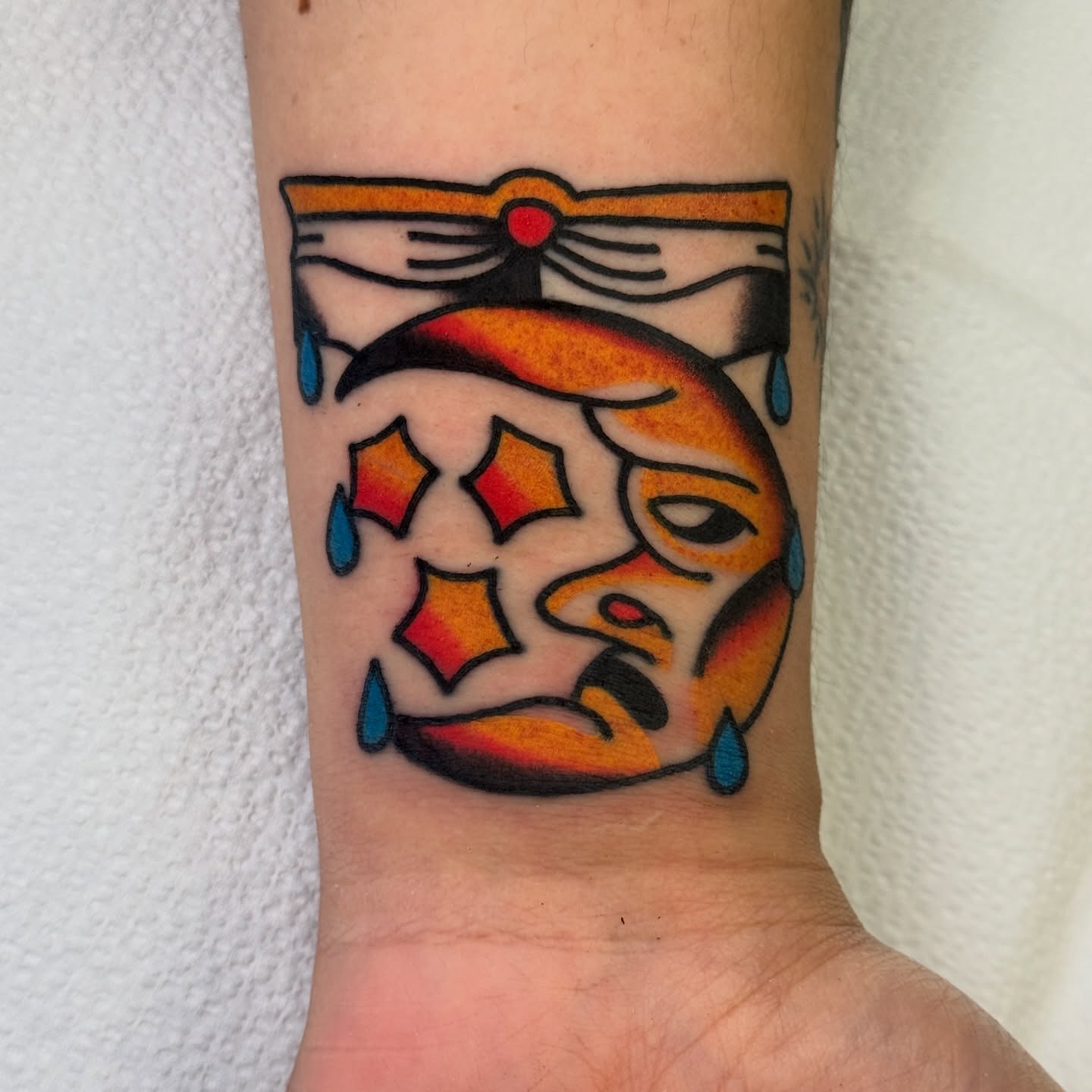 Mask with stars American traditional tattoo on the forearm by Rafael Torres, San Francisco, California