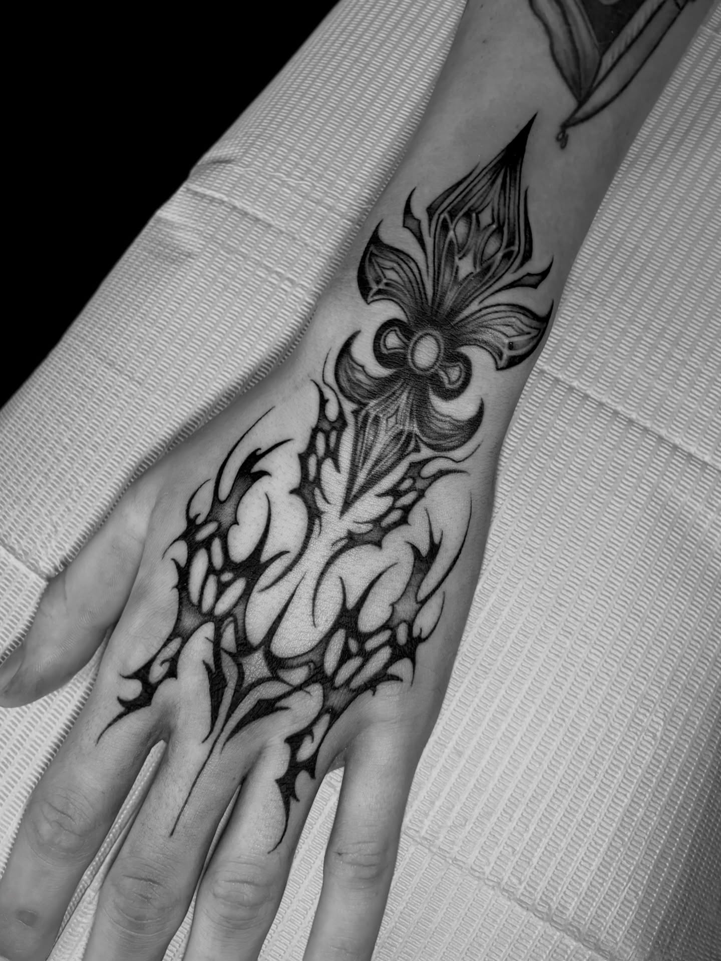 Floral design black and grey tattoo on the hand by Elixabeth
