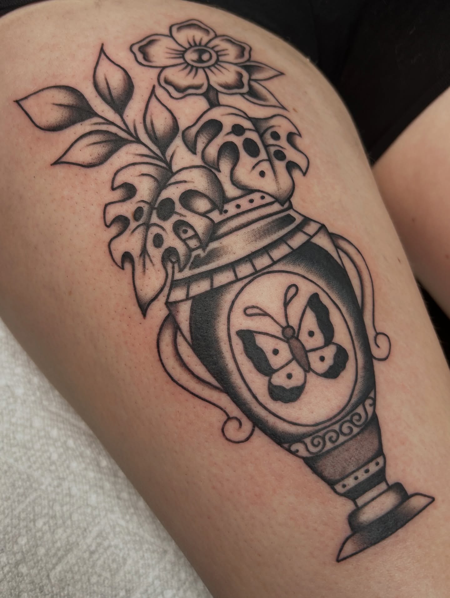 Clock with butterflies black and grey tattoo on the thigh by Dylan James