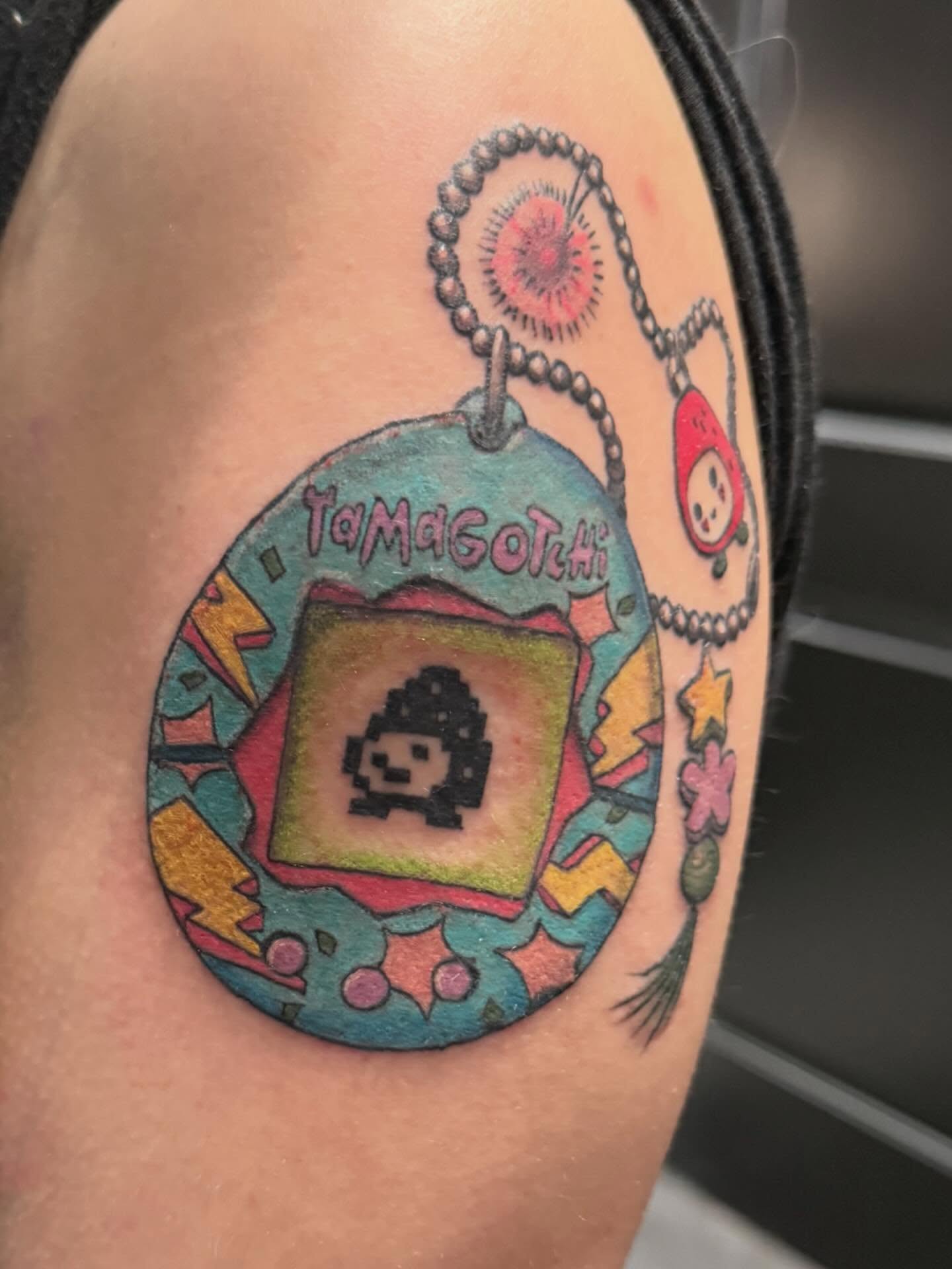 Tamagotchi dotwork tattoo on the shoulder by Courtney