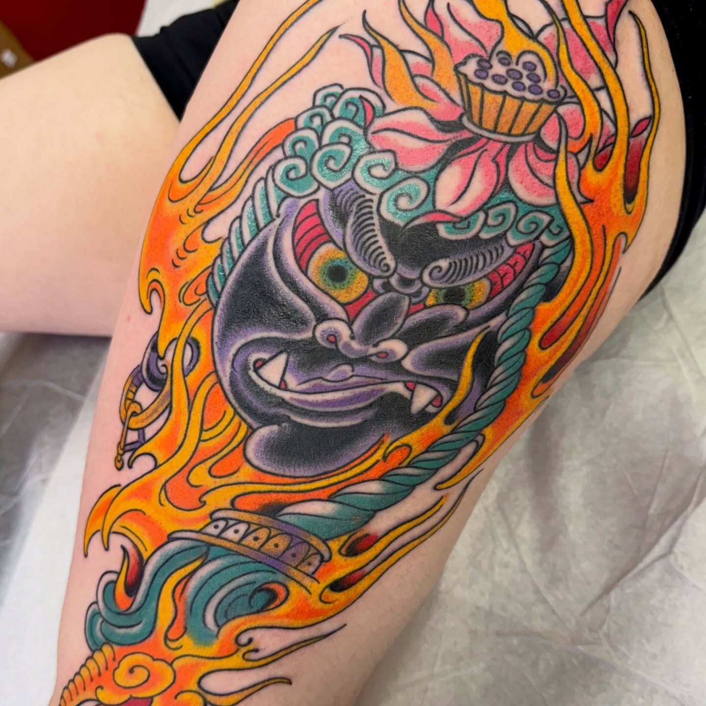 Demon mask American traditional tattoo on the thigh by Chris Orta