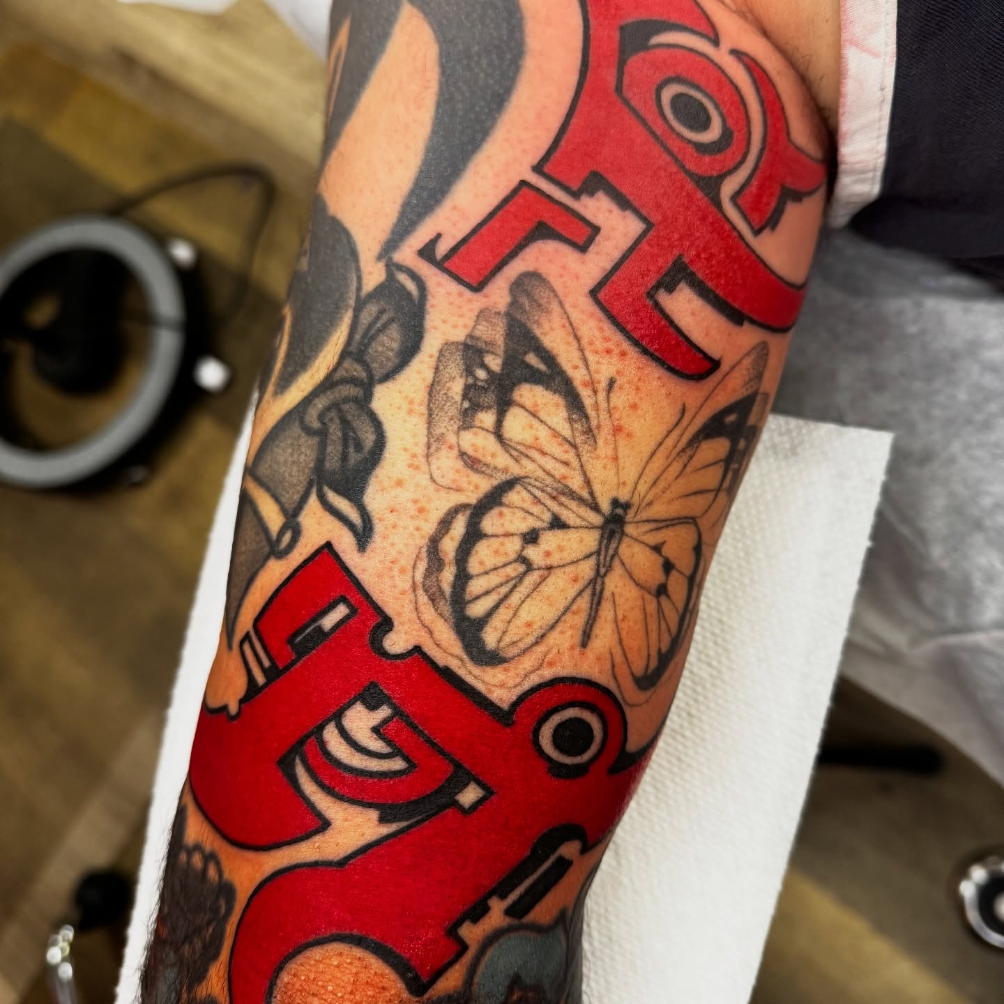 Butterfly and skull American traditional tattoo on the forearm by Chris Orta