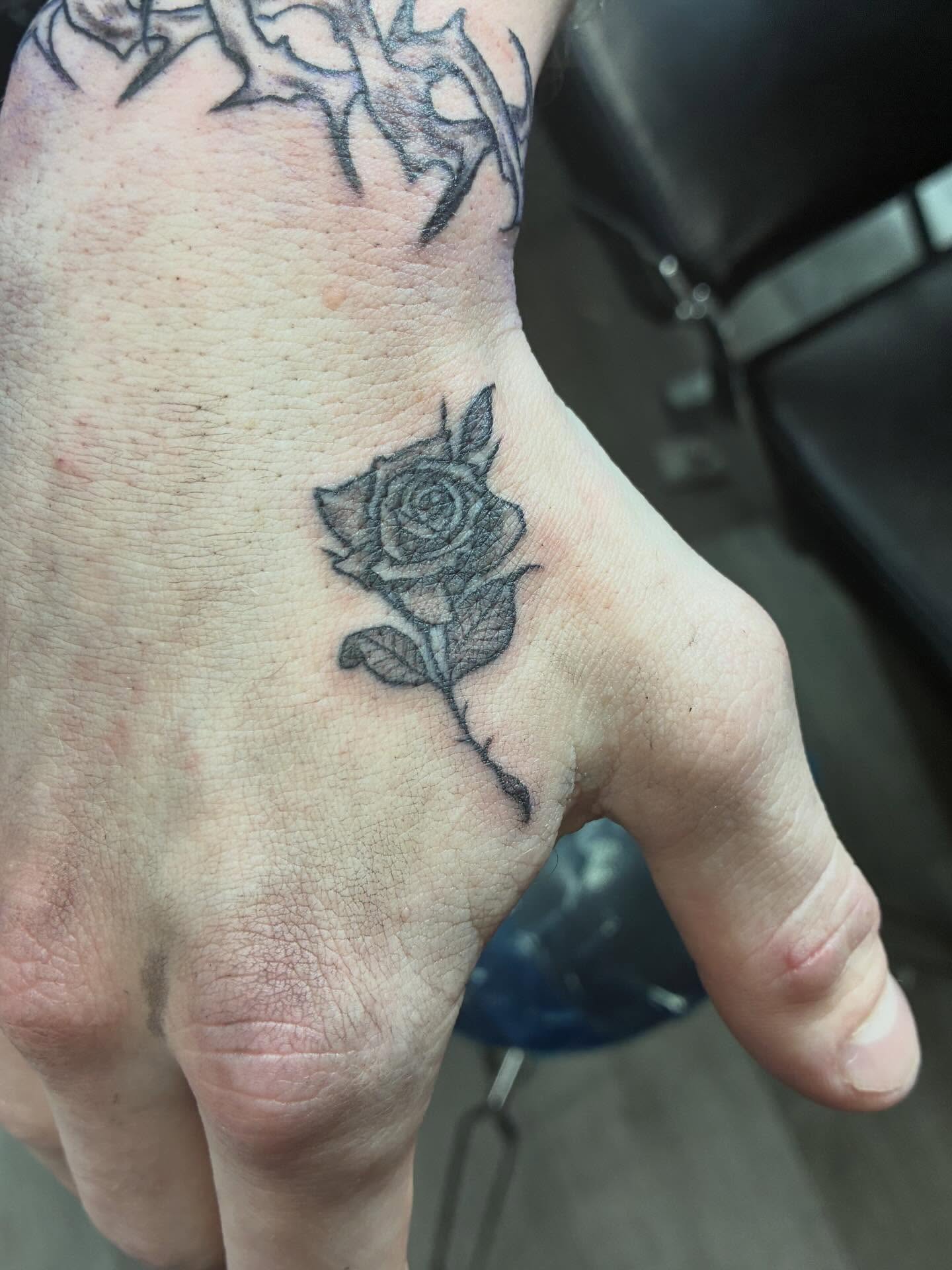 Rose black and grey tattoo on the hand by Trae