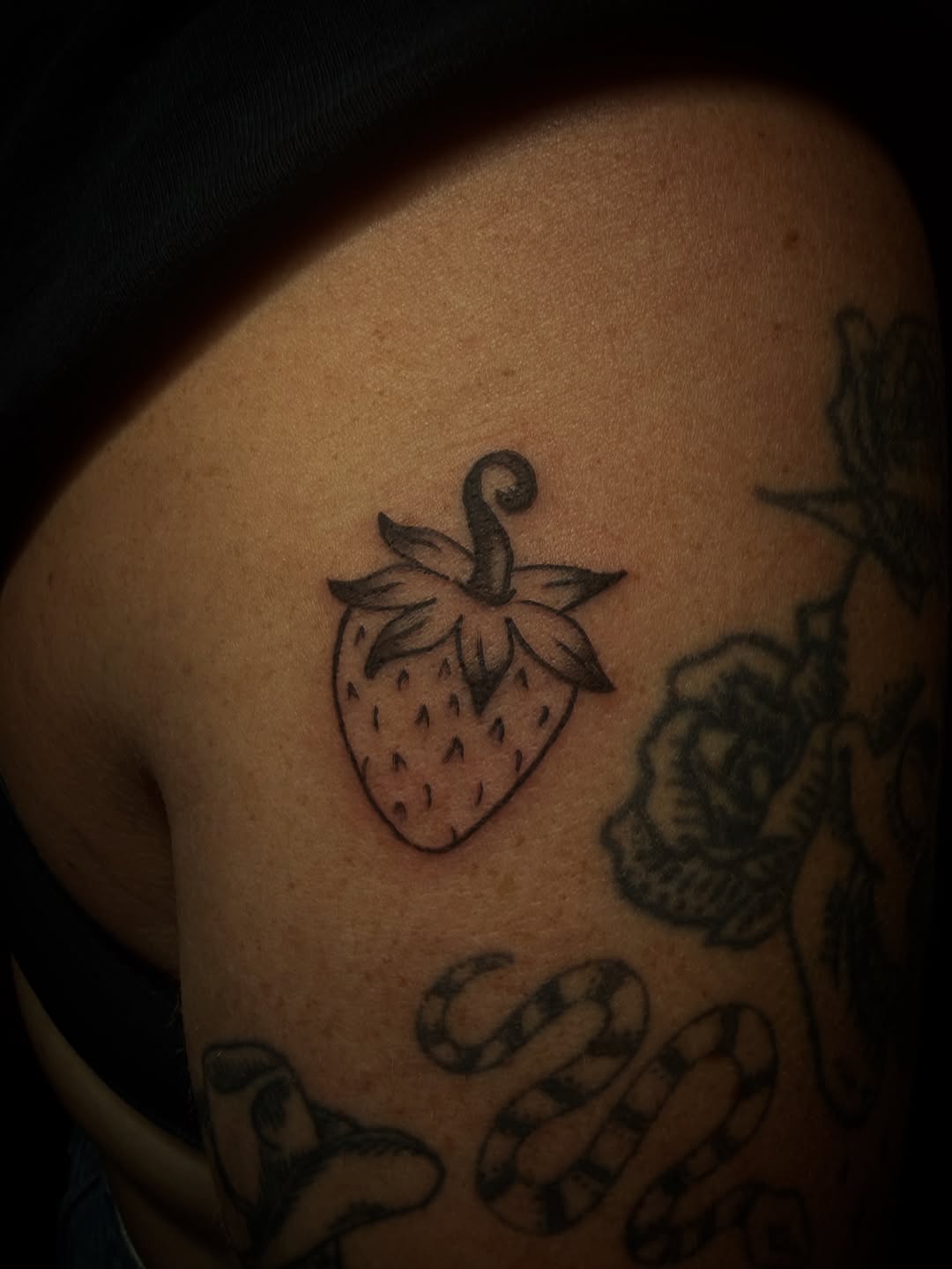 Strawberry minimalist tattoo on the shoulder by Lindsey