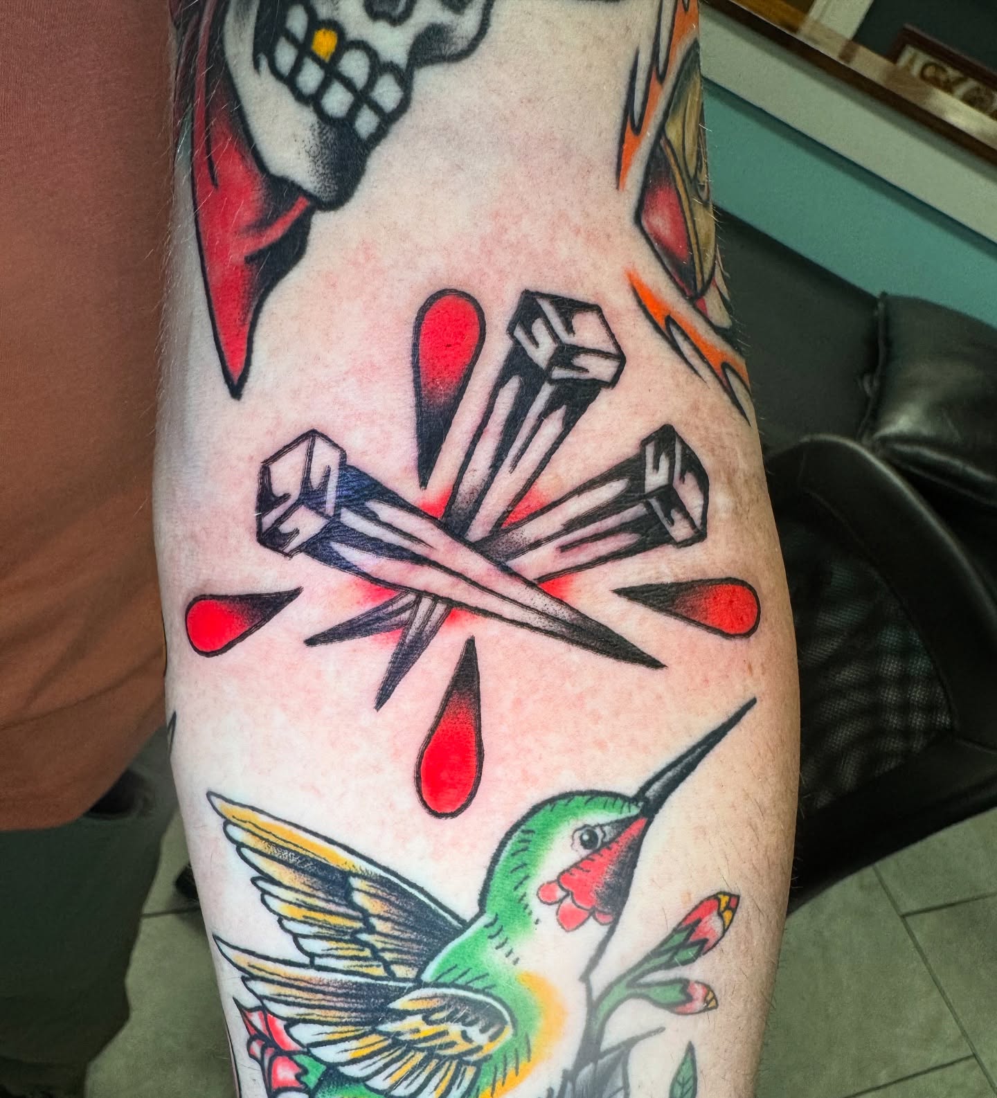 Crossed tools and hummingbird American traditional tattoo on the forearm by Kenneth Gibson