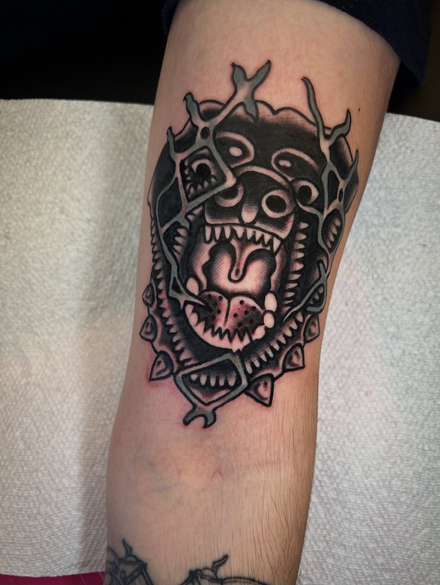 Demon mask black and grey tattoo on the forearm by Kit Miller, Indianapolis, Indiana