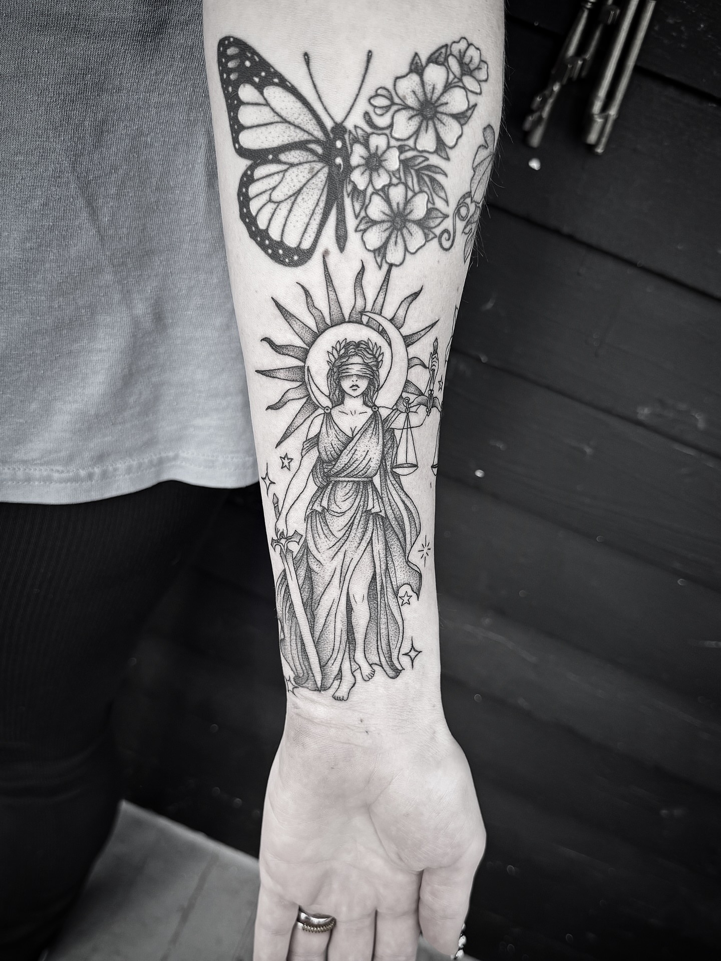 Statue of justice dotwork tattoo on the forearm by Breezy Tucker
