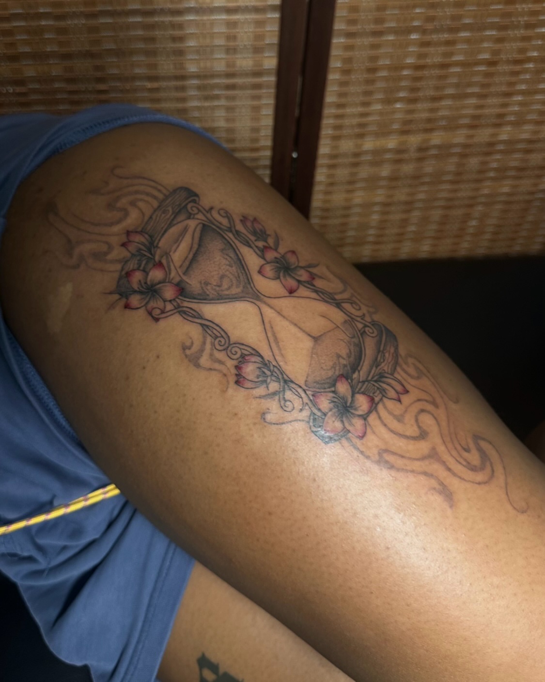 Hourglass with flowers black and grey tattoo on the thigh by jun