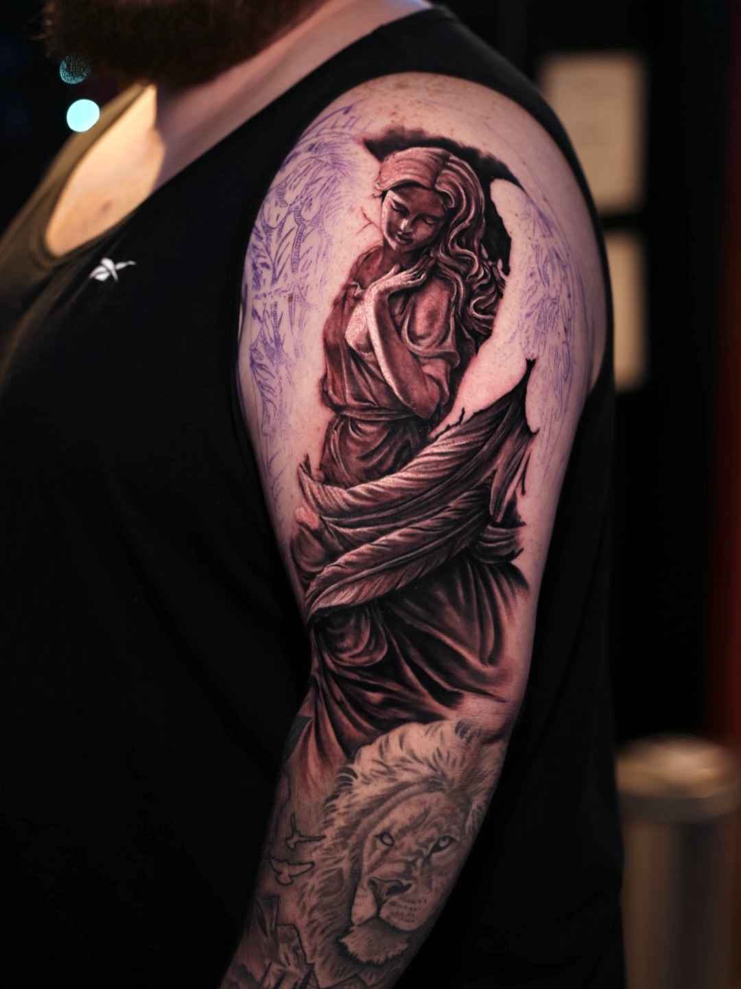 Angel with lion realism tattoo on the upper arm by Brandon Sontag