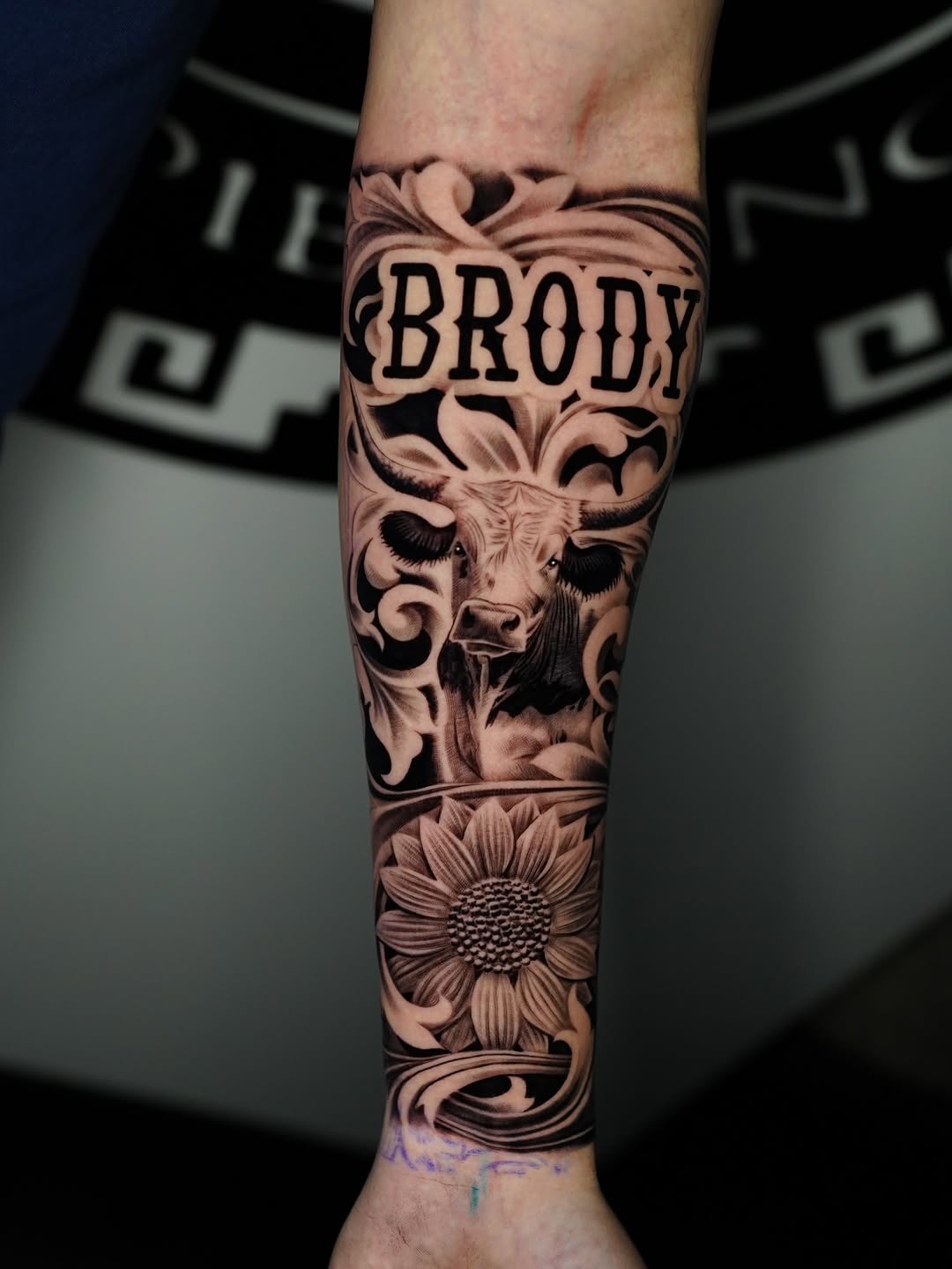 Bull head and sunflower with name Chicano tattoo on the forearm by Salvador Saenz Jr, Dallas, Texas
