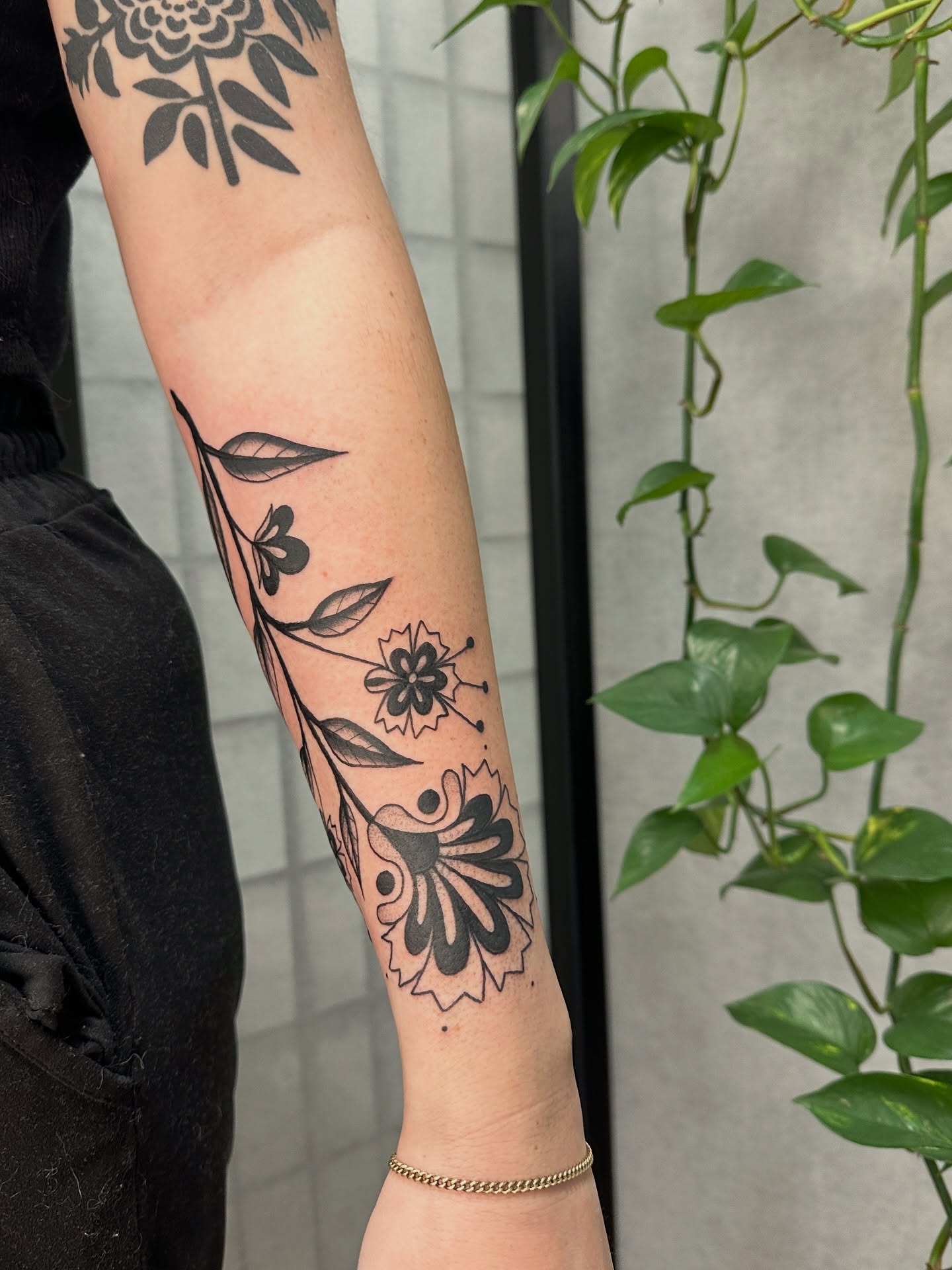 Floral design black and grey tattoo on the forearm by Hannah Eddy