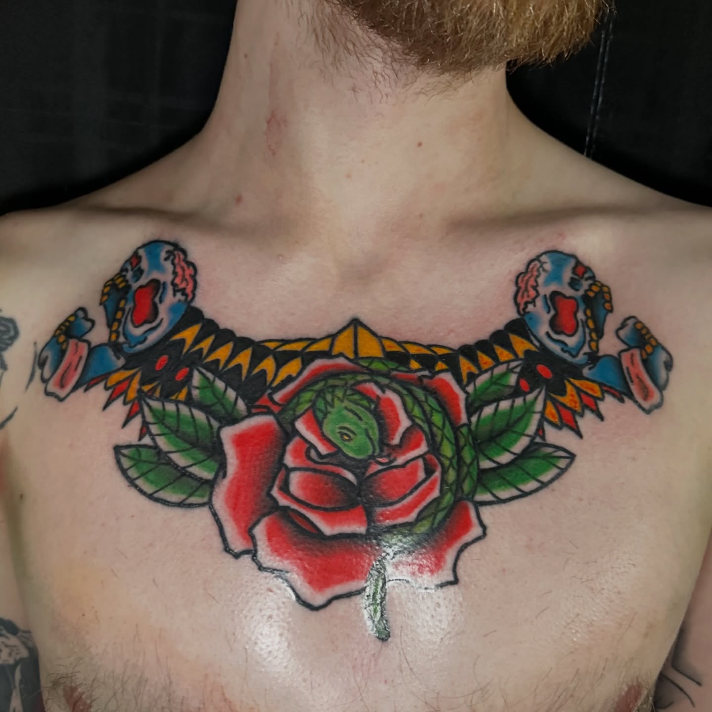 Rose with skulls American traditional tattoo on the chest by Drew’s Tattoos (NH)