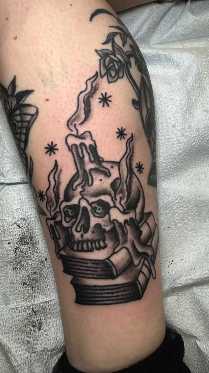 Skull candle on books minimalist tattoo on the forearm by Michael Roehrich (MEECH!)