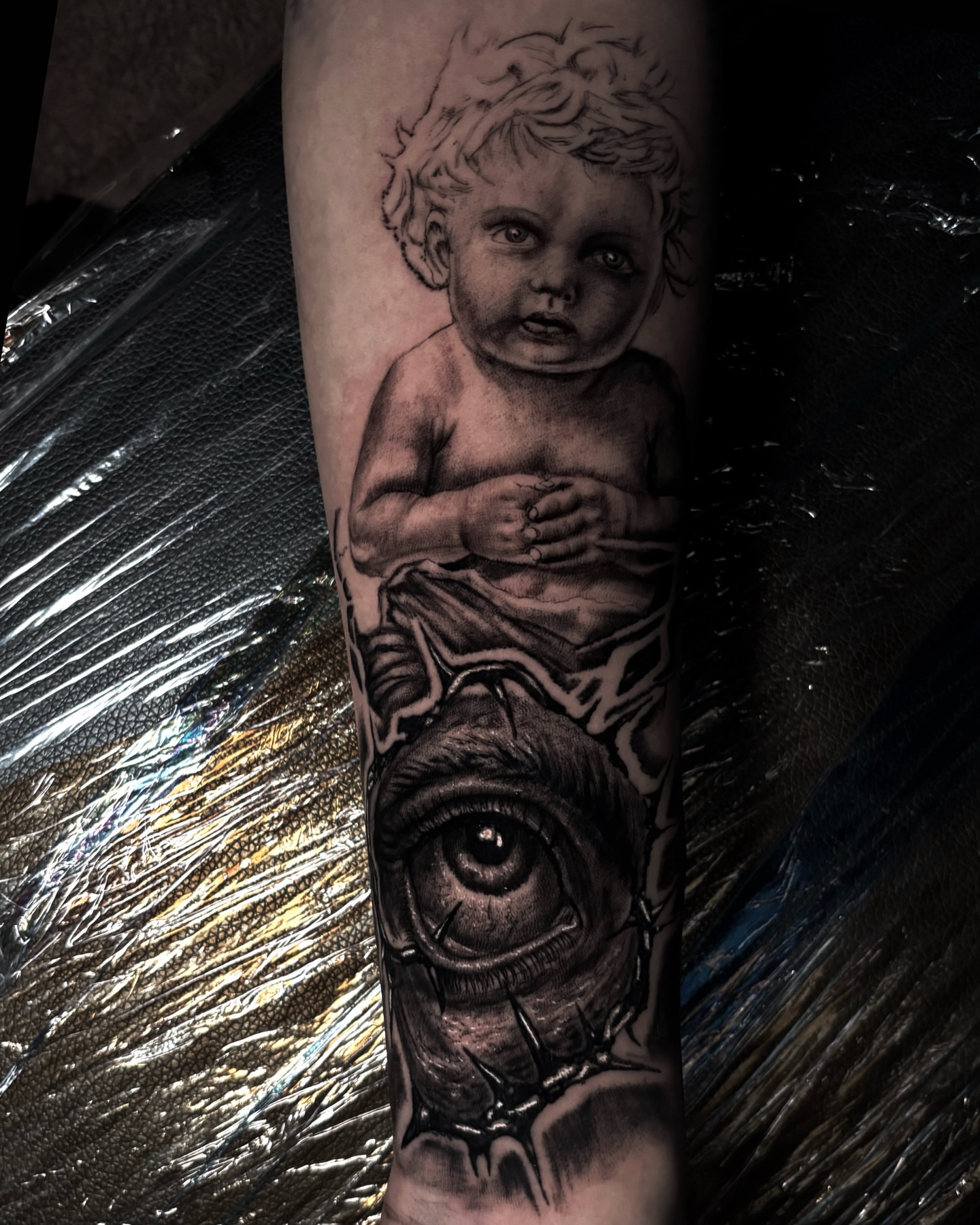 Child and eye realism tattoo on the forearm by Trev