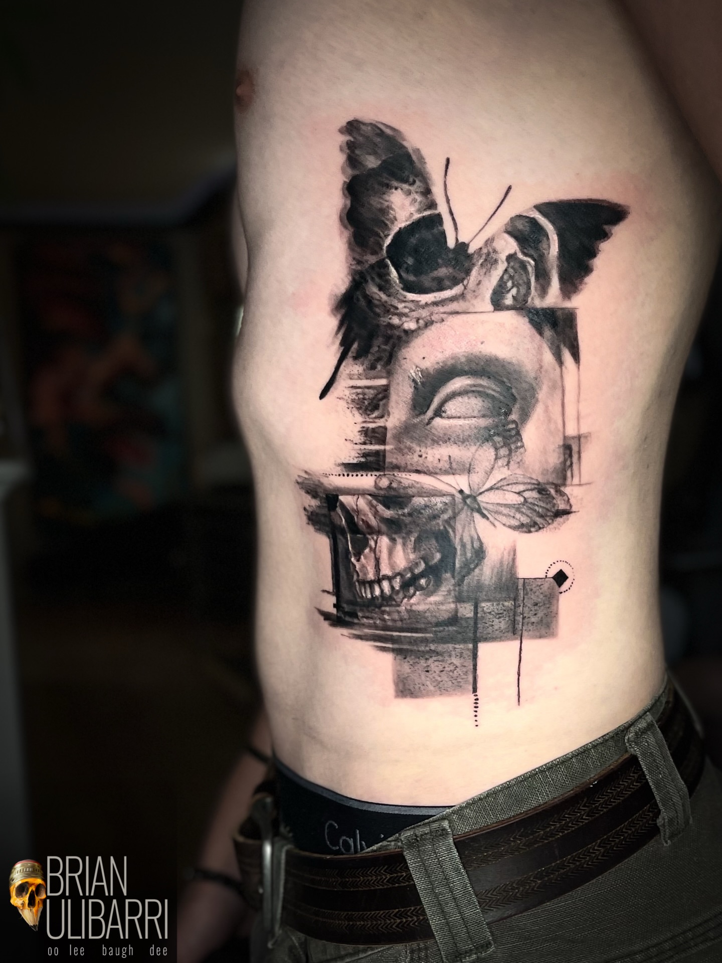 Skull and butterfly realism tattoo on the ribs by Brian Ulibarri