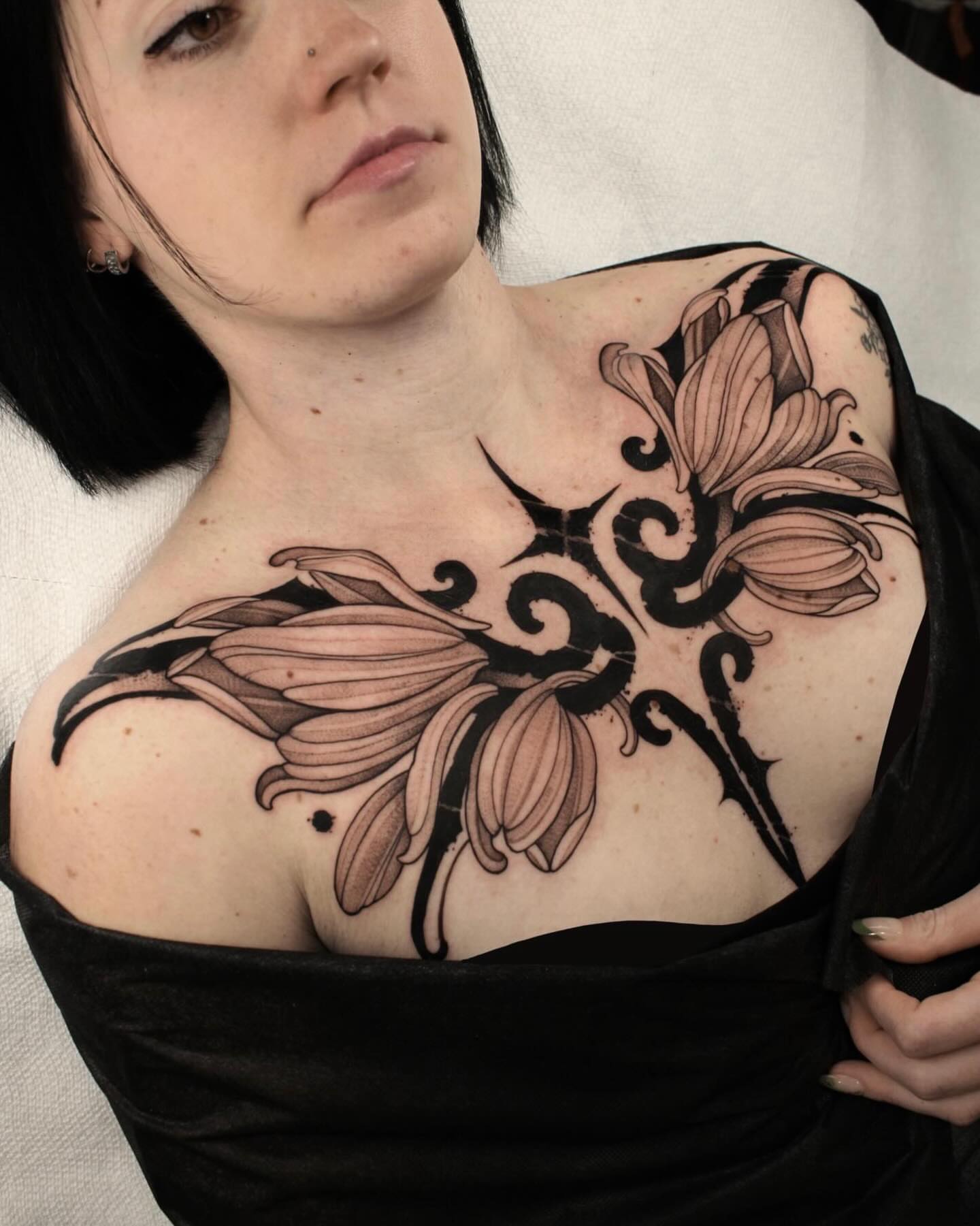 Lilies black and grey tattoo on the chest by Heather Apgar