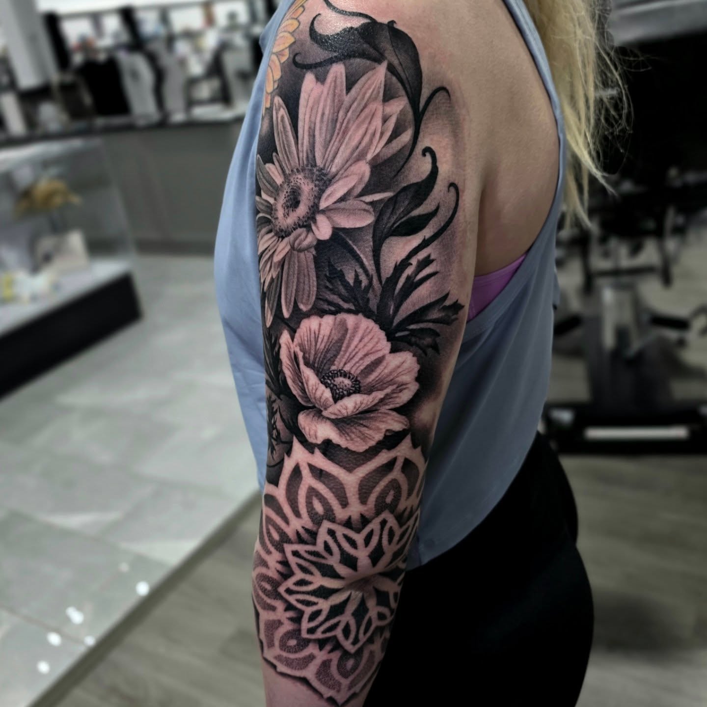 Floral bouquet realism tattoo on the upper arm by Julia Oravets