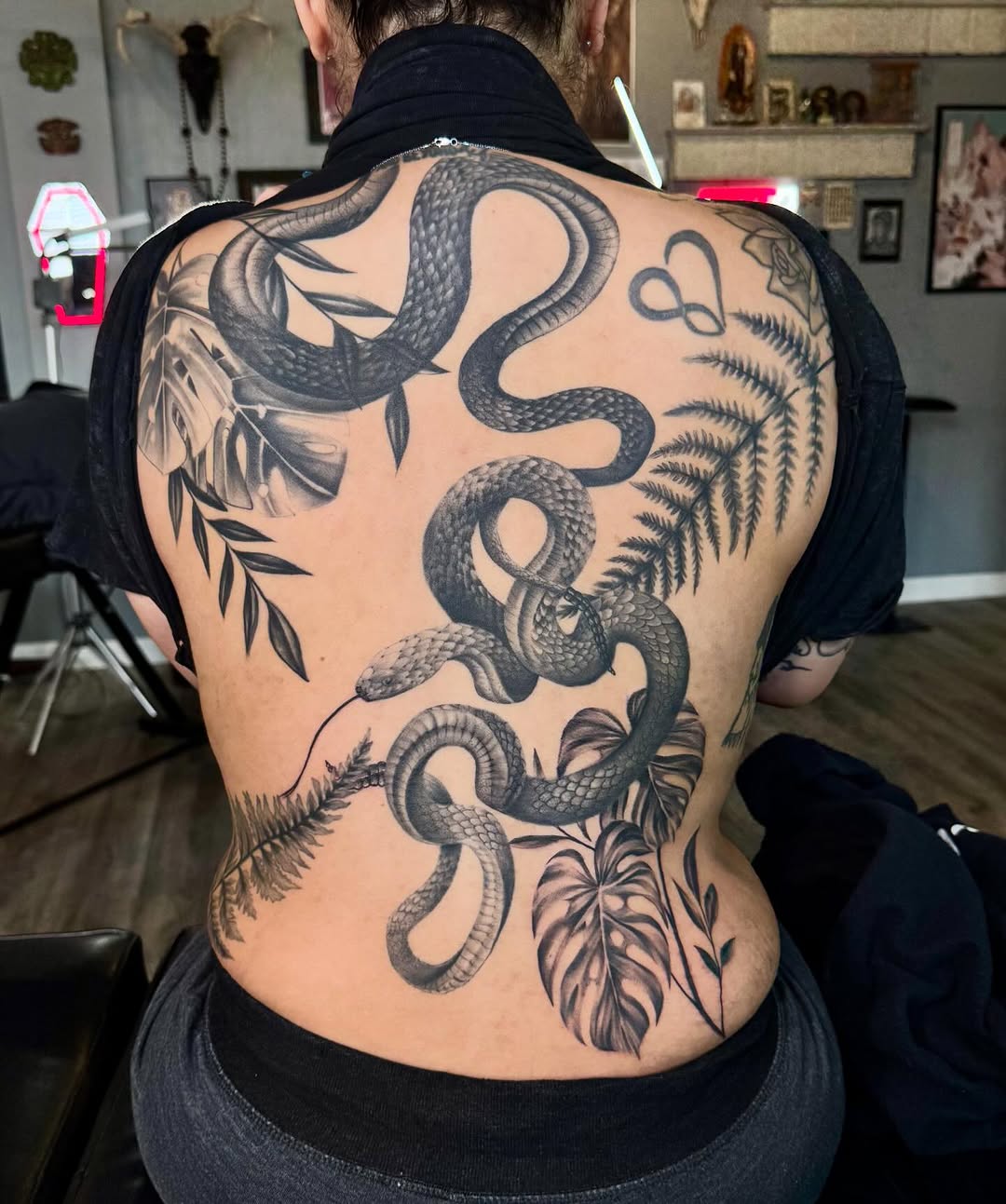 Snake and tropical leaves tribal tattoo on the back by Stephanie Cruz, Kansas City, Missouri