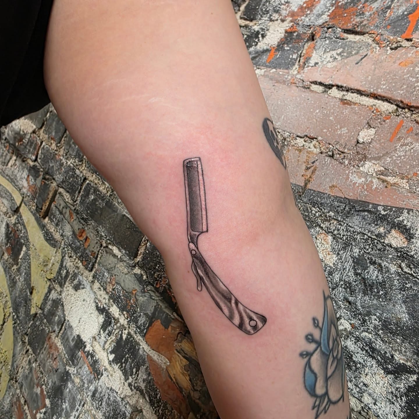 Straight razor black and grey tattoo on the forearm by Tattoos by Annie