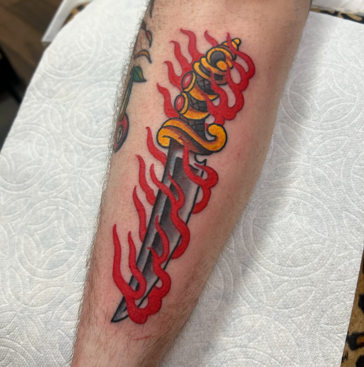 Flaming sword American traditional tattoo on the forearm by Vivian Nguyen