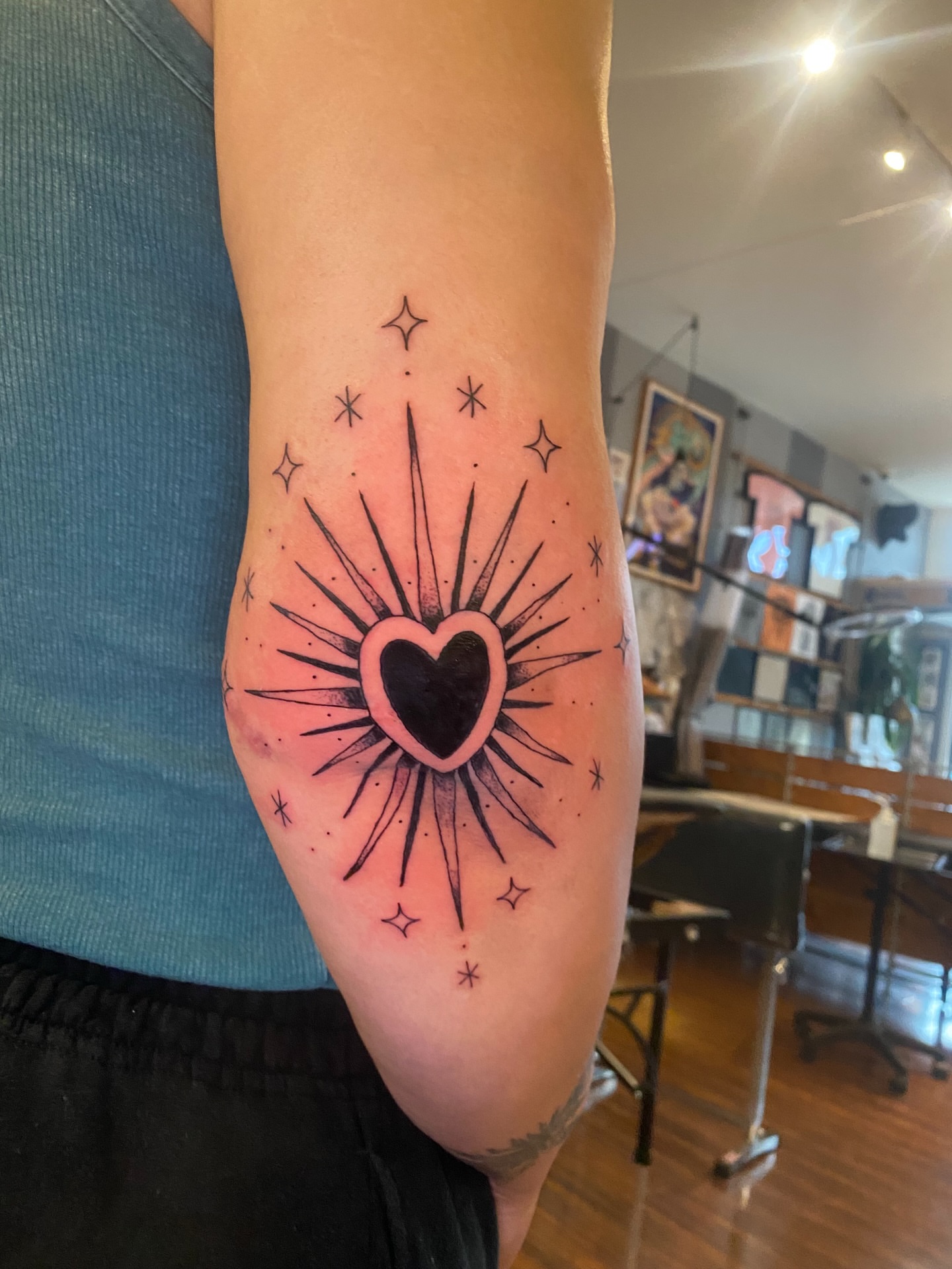 Heart with sunburst watercolor tattoo on the forearm by Melissa Contreras