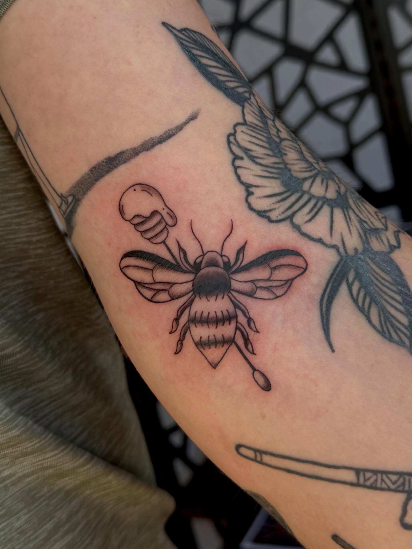 Bee and flower black and grey tattoo on the forearm by Alaska ⚜️