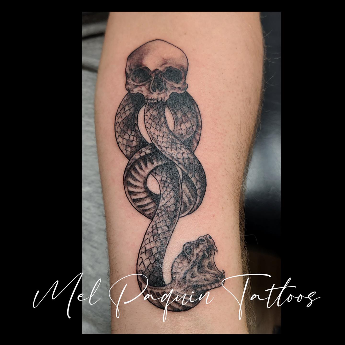 Snake and skull black and grey tattoo on the forearm by Mel Paquin