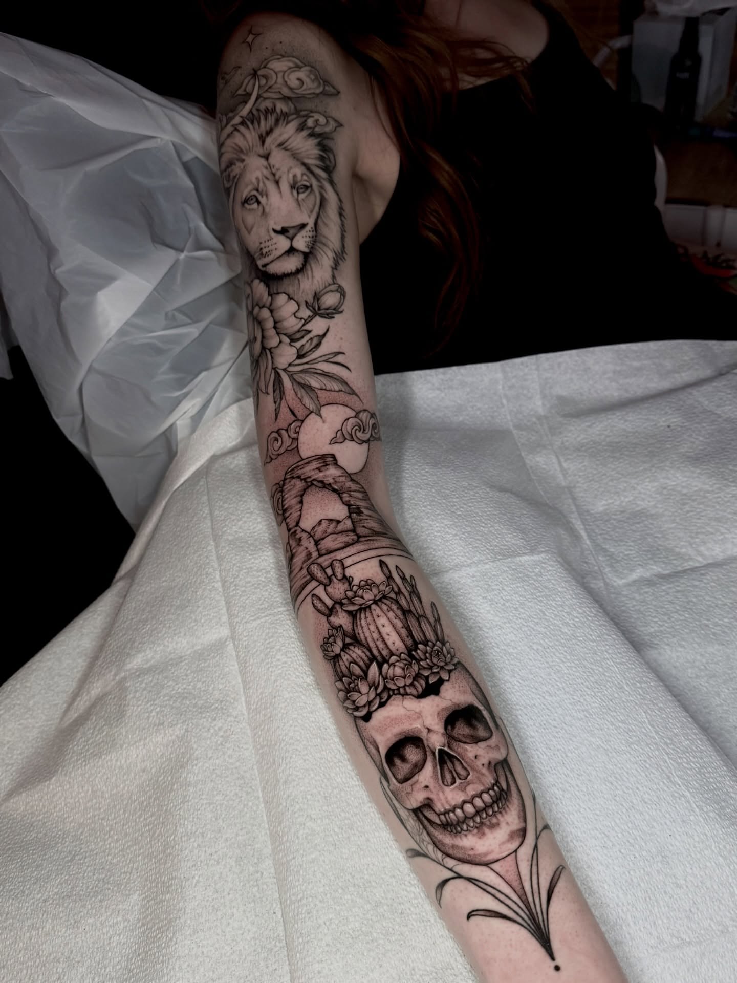 Lion and skull realism tattoo on the forearm by Kathryn Semus
