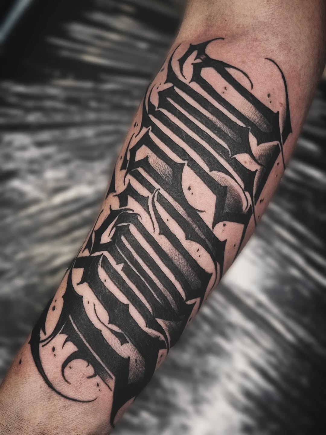 Gothic lettering Chicano tattoo on the forearm by AntiheroTattoo