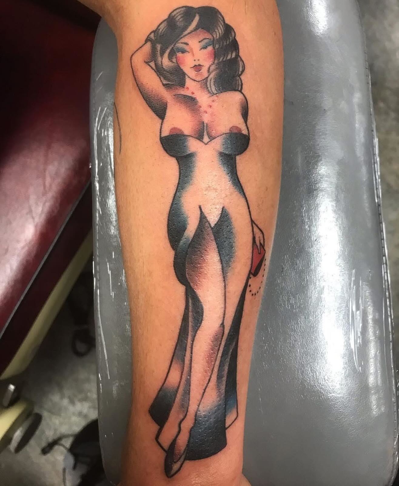 Pin-up girl American traditional tattoo on the forearm by Alan