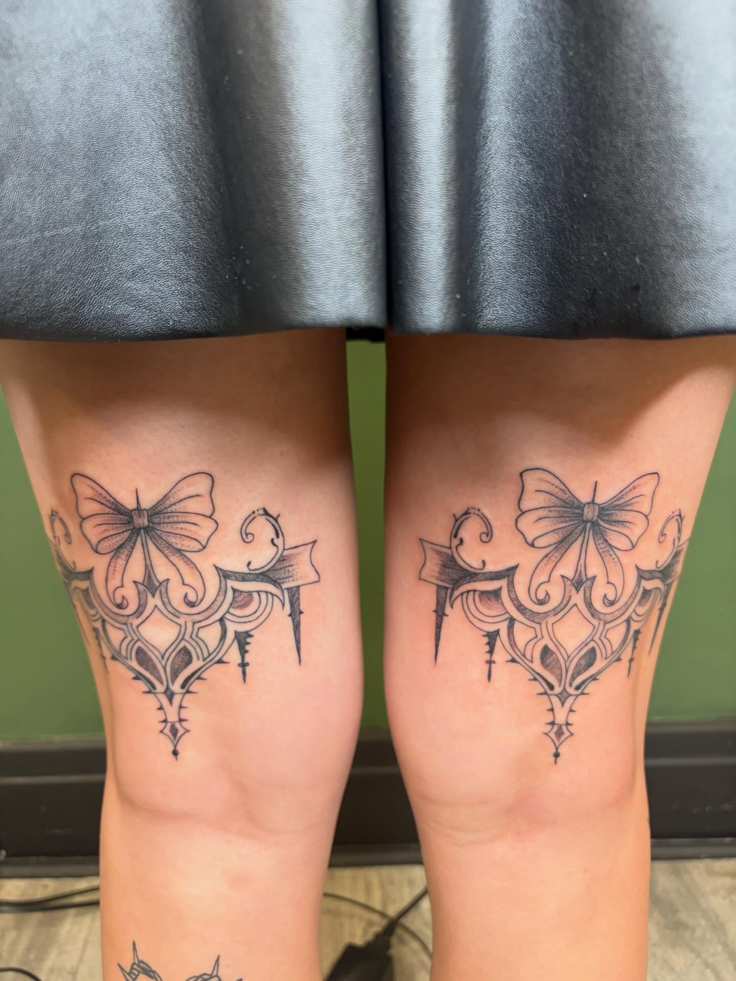 Bow and ornamental design geometric tattoo on the thigh by Sum'er Daize Tattoos