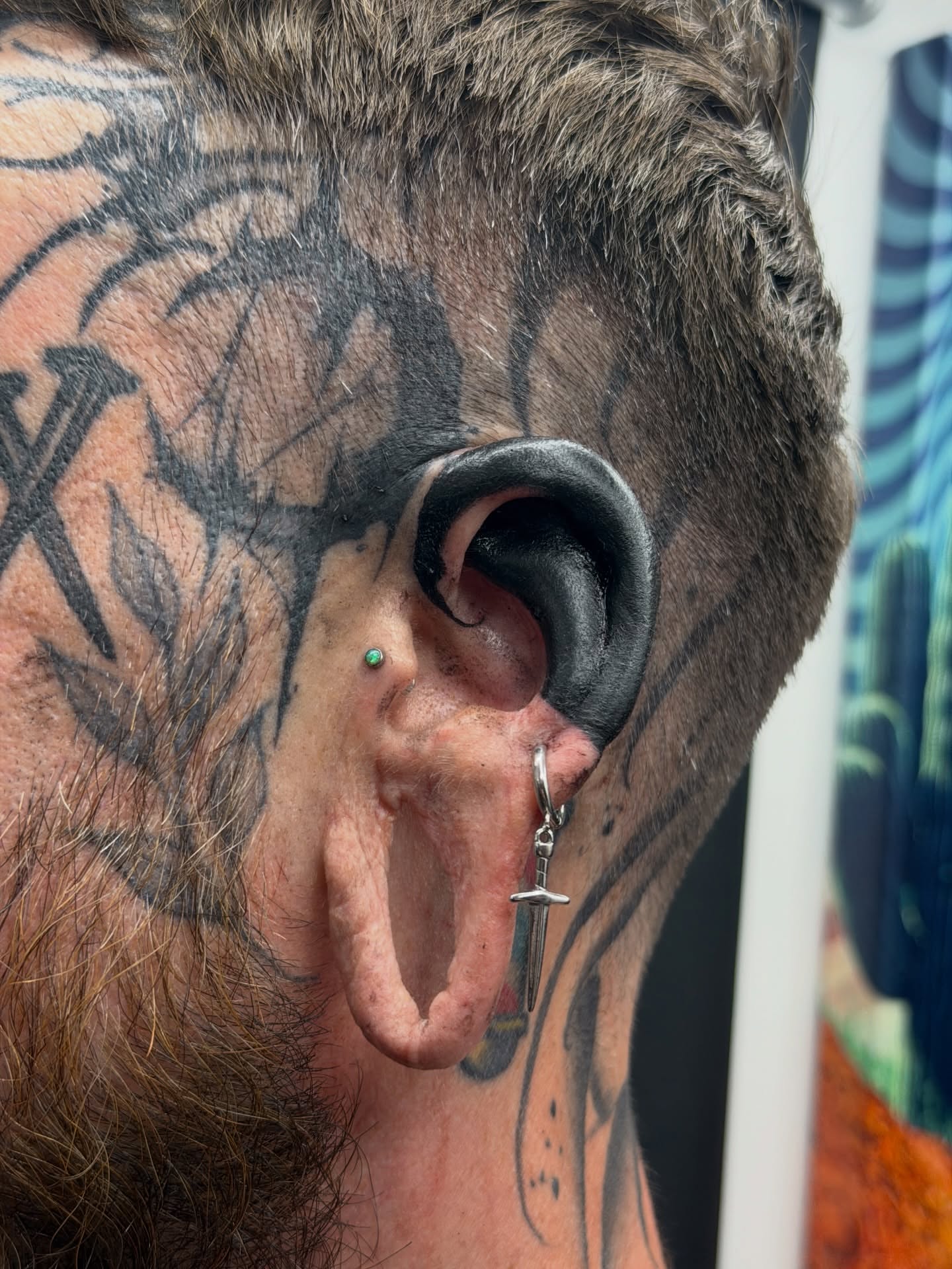 Ear piercing black and grey tattoo on the head by Denver Blackout Tattoo Specialist - Anthony