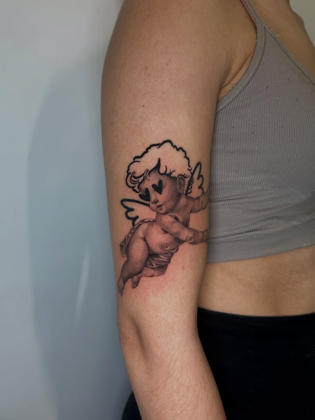 Cherub with heart eyes ignorant tattoo on the forearm by 𝘋𝘪𝘢𝘯𝘯𝘢