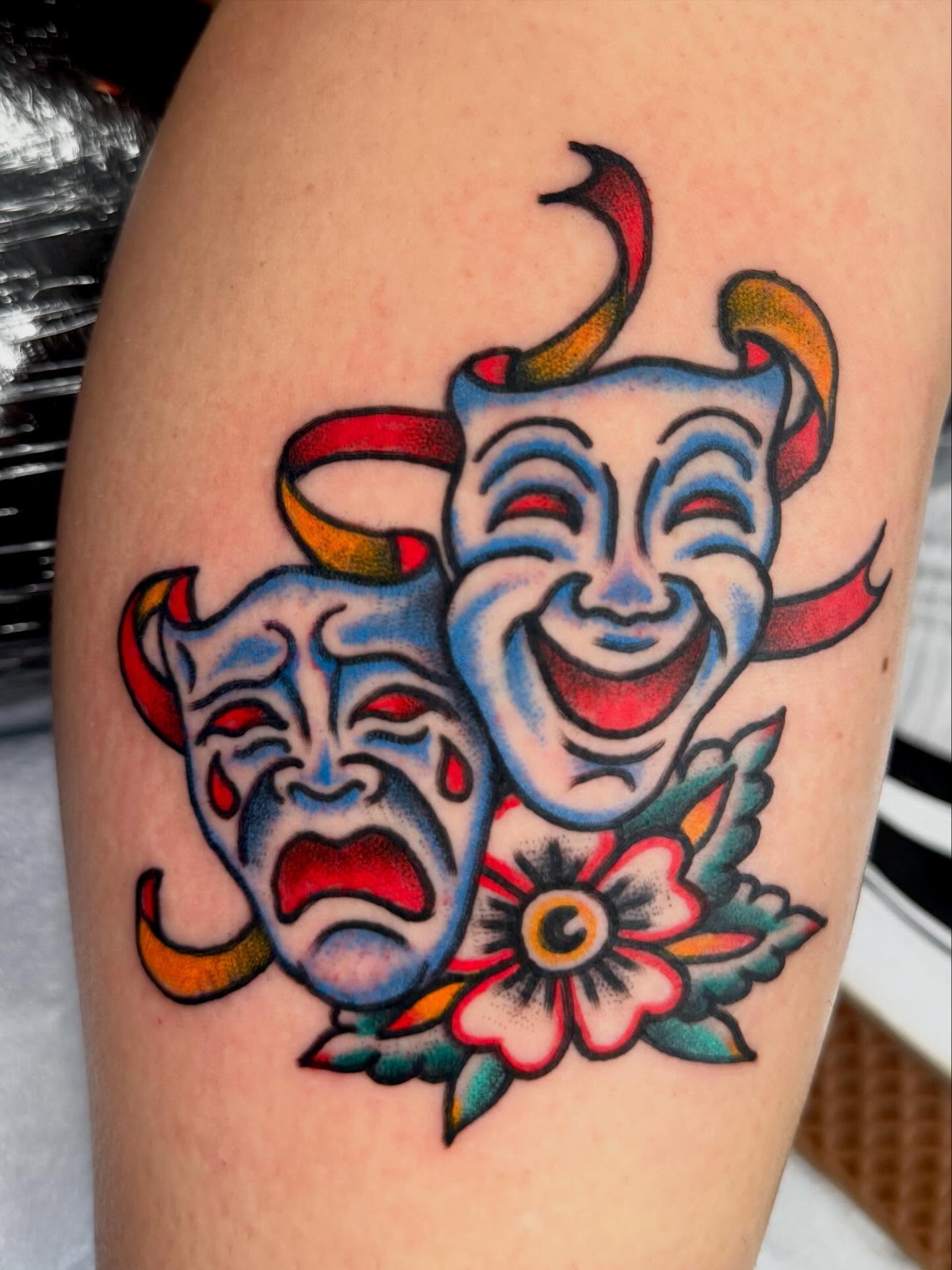 Theater masks American traditional tattoo on the thigh by Jesse Boss, Nashville, Tennessee