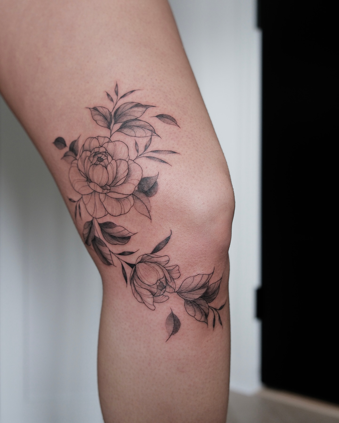 Peony flowers black and grey tattoo on the thigh by Haley Sayers