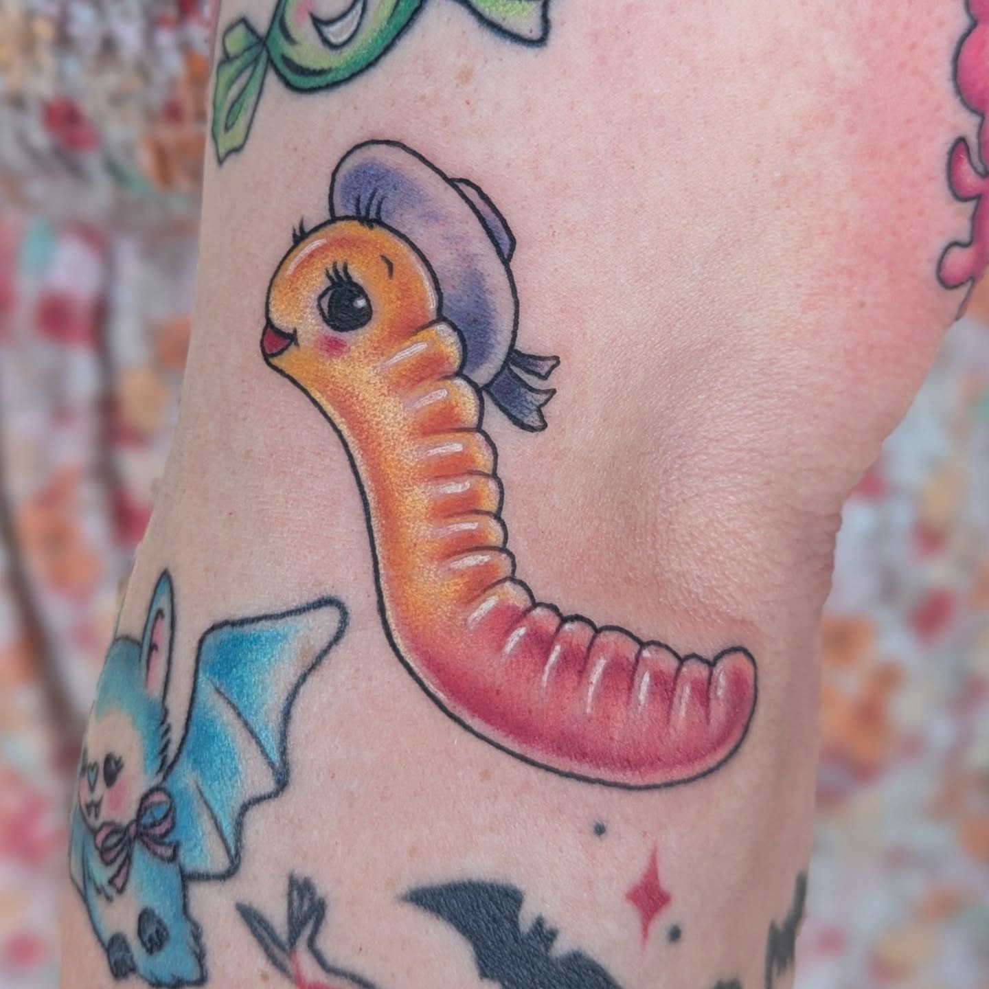 Worm wearing hat American traditional tattoo on the forearm by Angie Meuth