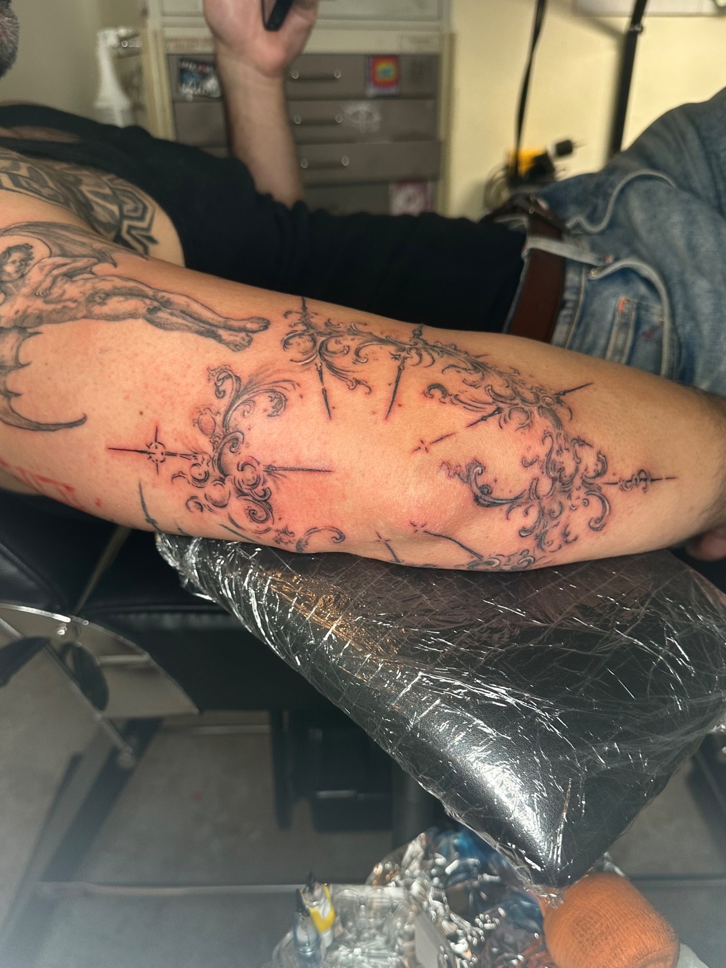 Mythical creature and floral ornamental tattoo on the forearm by Quin Walker