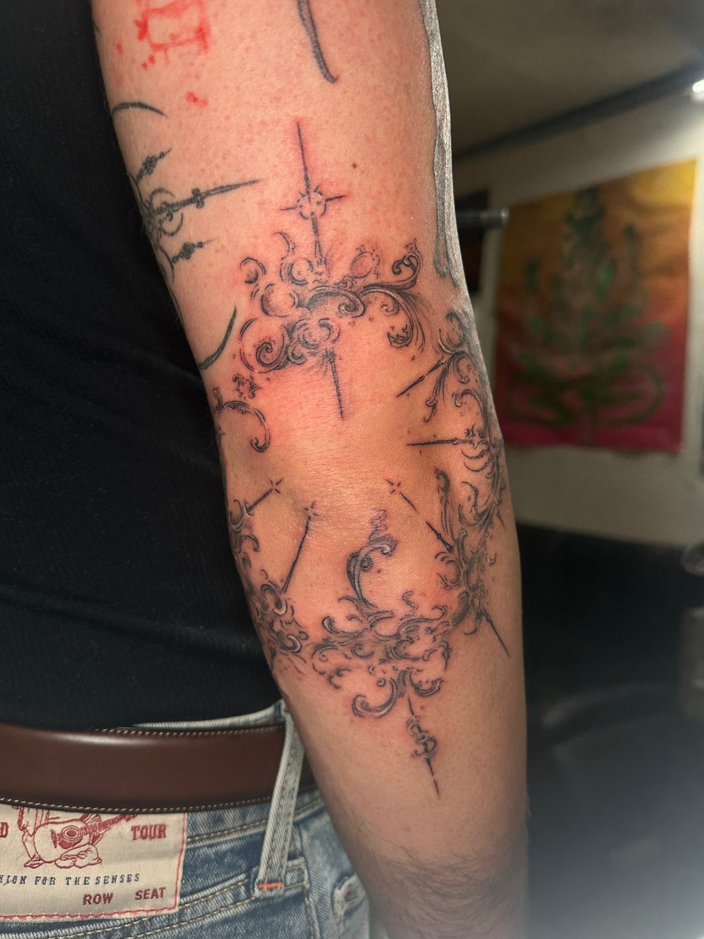Cross and ornamental swirls ornamental tattoo on the forearm by Quin Walker