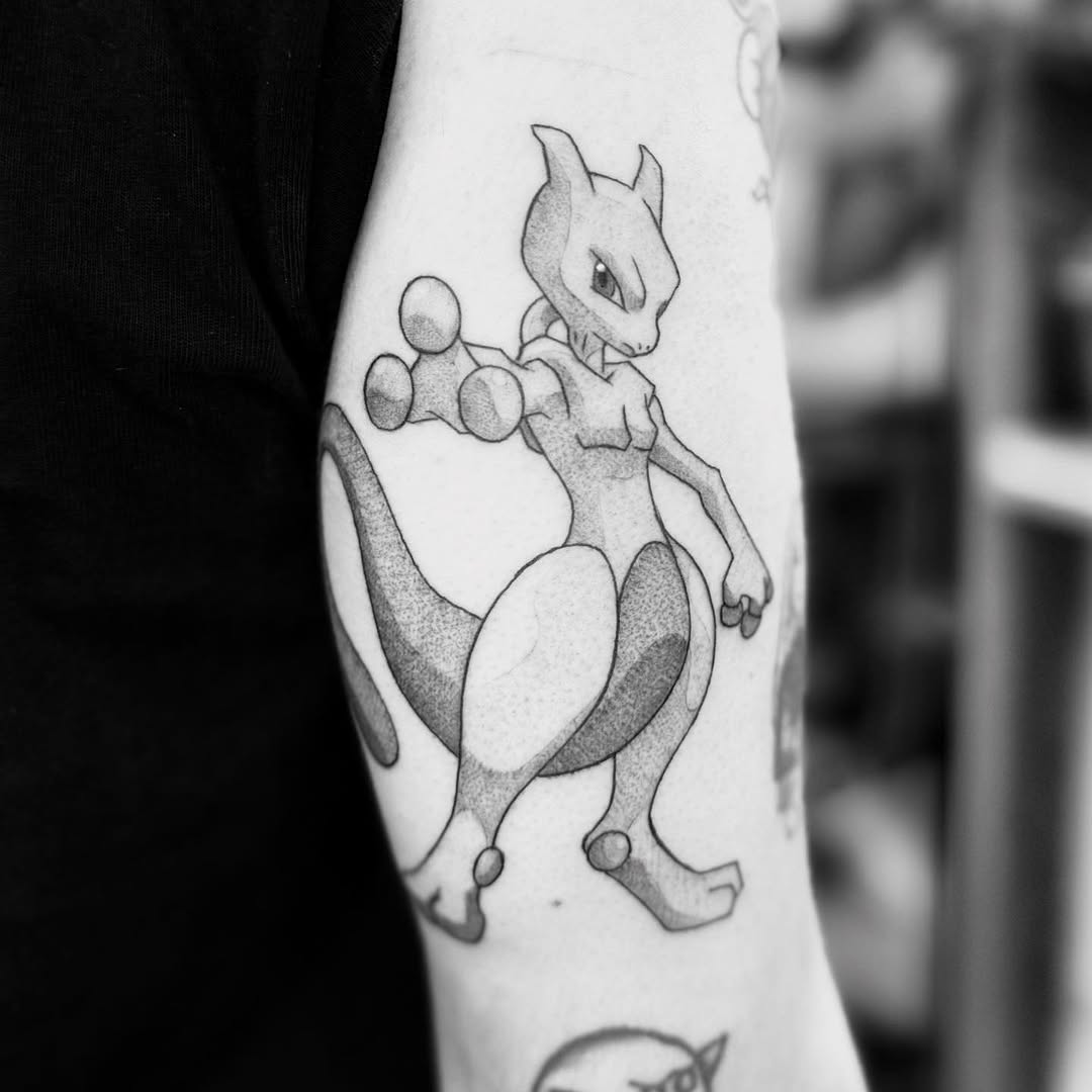 Mewtwo from Pokemon new school tattoo on the forearm by Rigo Vargas