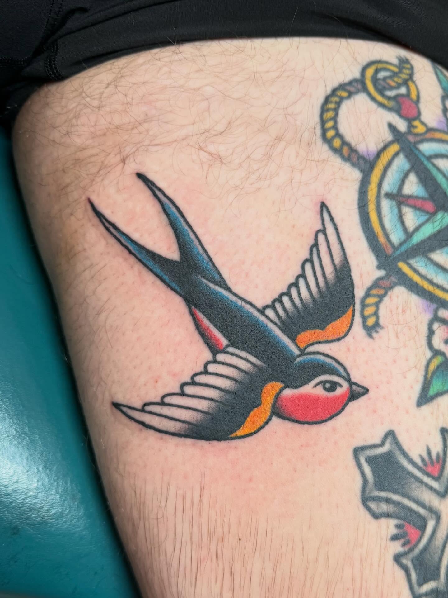 Swallow American traditional tattoo on the thigh by Bill Crawford, Plymouth, Michigan